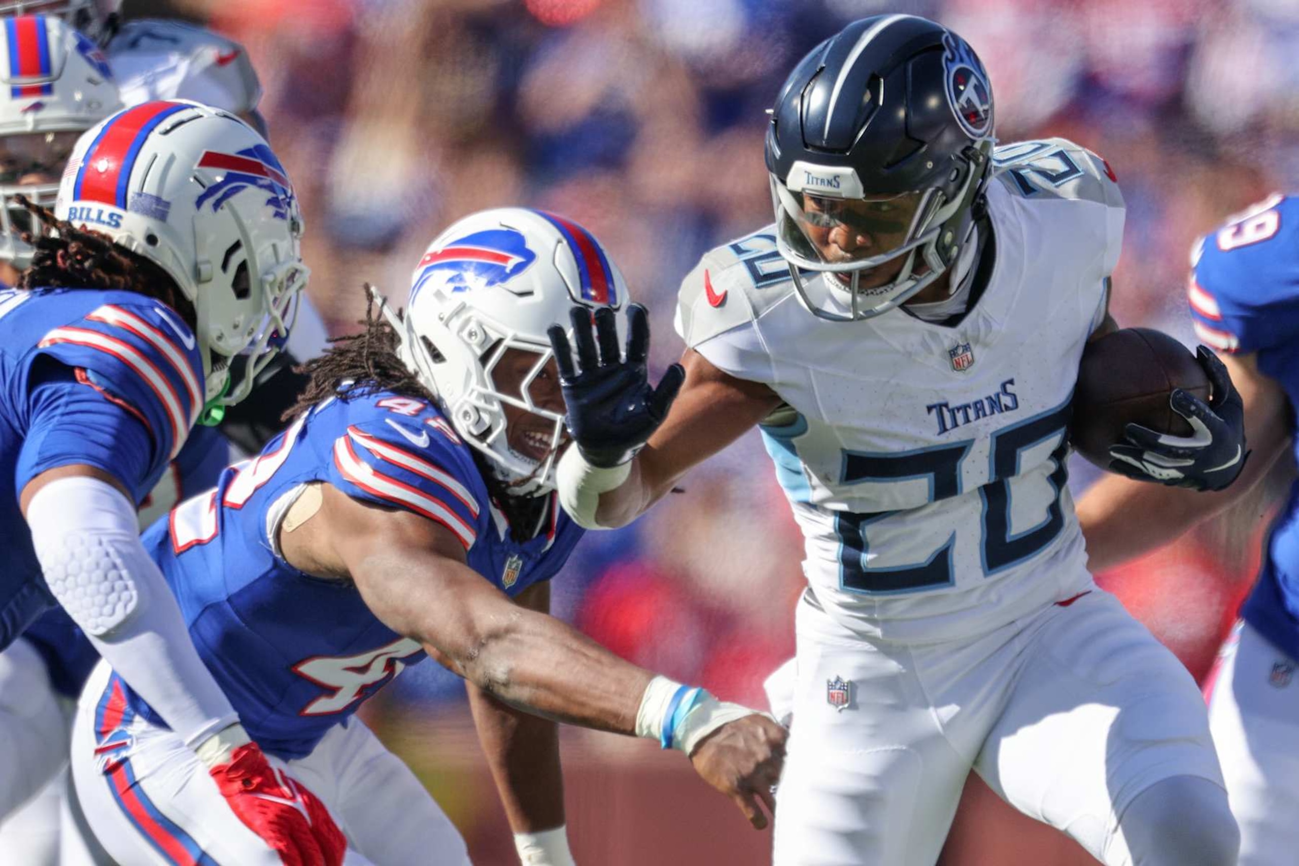 ORCHARD PARK, NEW YORK - OCTOBER 20: Tony Pollard #20 of the Tennessee Titans runs the ball as Dorian Williams #42 of the Buffalo Bills reaches during the first quarter at Highmark Stadium on October 20, 2024 in Orchard Park, New York. (Photo by Bryan Bennett/Getty Images)