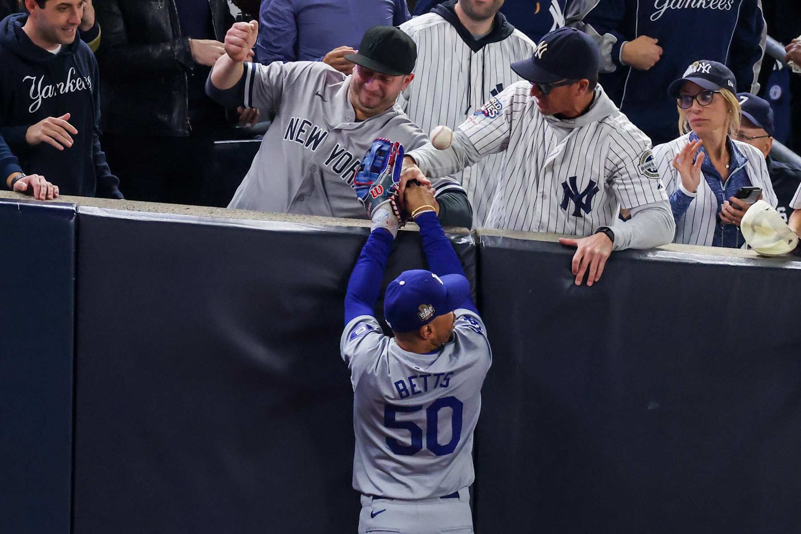 NEW YORK, NEW YORK - OCTOBER 29: Fans interfere with Mookie Betts #50 of the Los Angeles Dodgers as he attempts to catch a fly ball in foul territory during the first inning of Game Four of the 2024 World Series against the New York Yankees at Yankee Stadium on October 29, 2024 in the Bronx borough of New York City. The play resulted in an out. (Photo by Al Bello/Getty Images) NEW YORK, NEW YORK - OCTOBER 29: Fans interfere with Mookie Betts #50 of the Los Angeles Dodgers as he attempts to catch a fly ball in foul territory during the first inning of Game Four of the 2024 World Series against the New York Yankees at Yankee Stadium on October 29, 2024 in the Bronx borough of New York City. The play resulted in an out. (Photo by Al Bello/Getty Images)