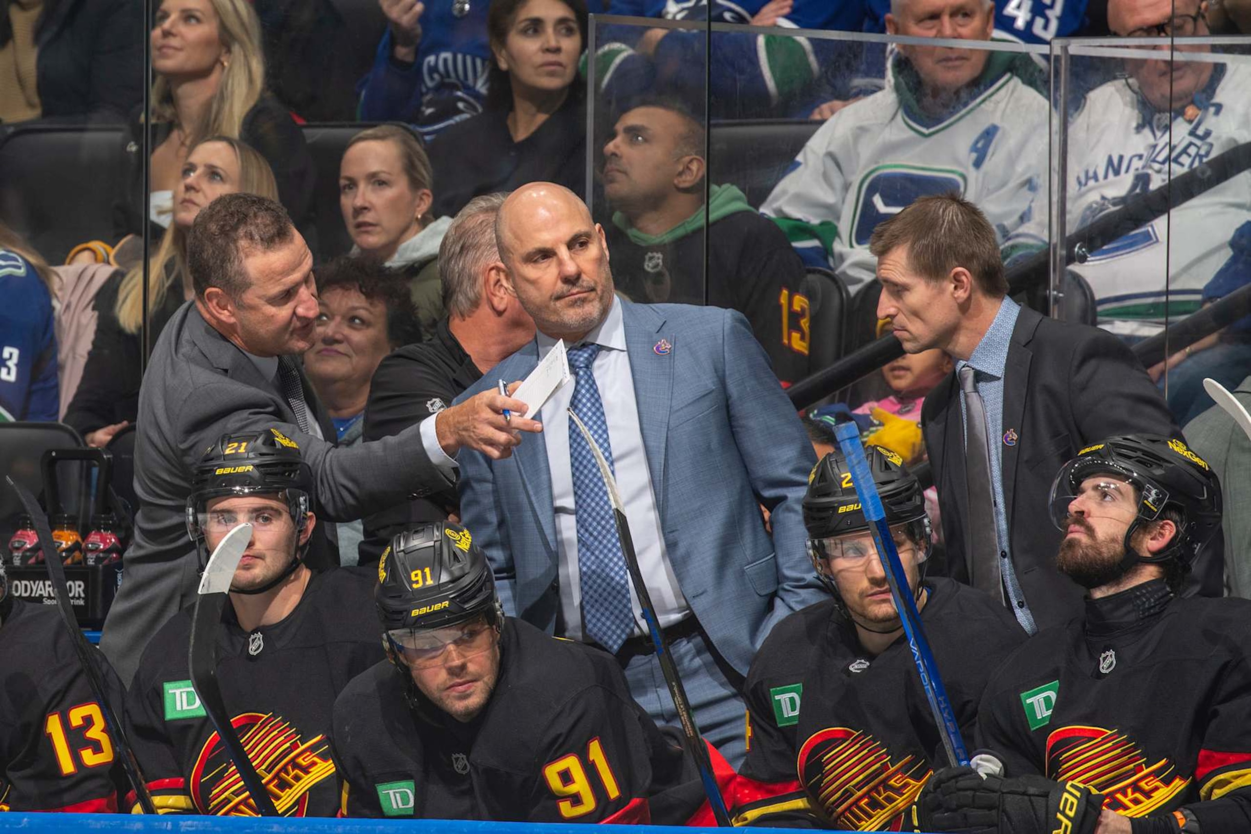 VANCOUVER, CANADA - OCTOBER 28: Head coach Rick Tocchet of the Vancouver Canucks and assistant coach Adam Foote of the Vancouver Canucks during the second period of their NHL game against the Carolina Hurricanes at Rogers Arena on October 28, 2024 in Vancouver, British Columbia, Canada.  (Photo by Jeff Vinnick/NHLI via Getty Images)