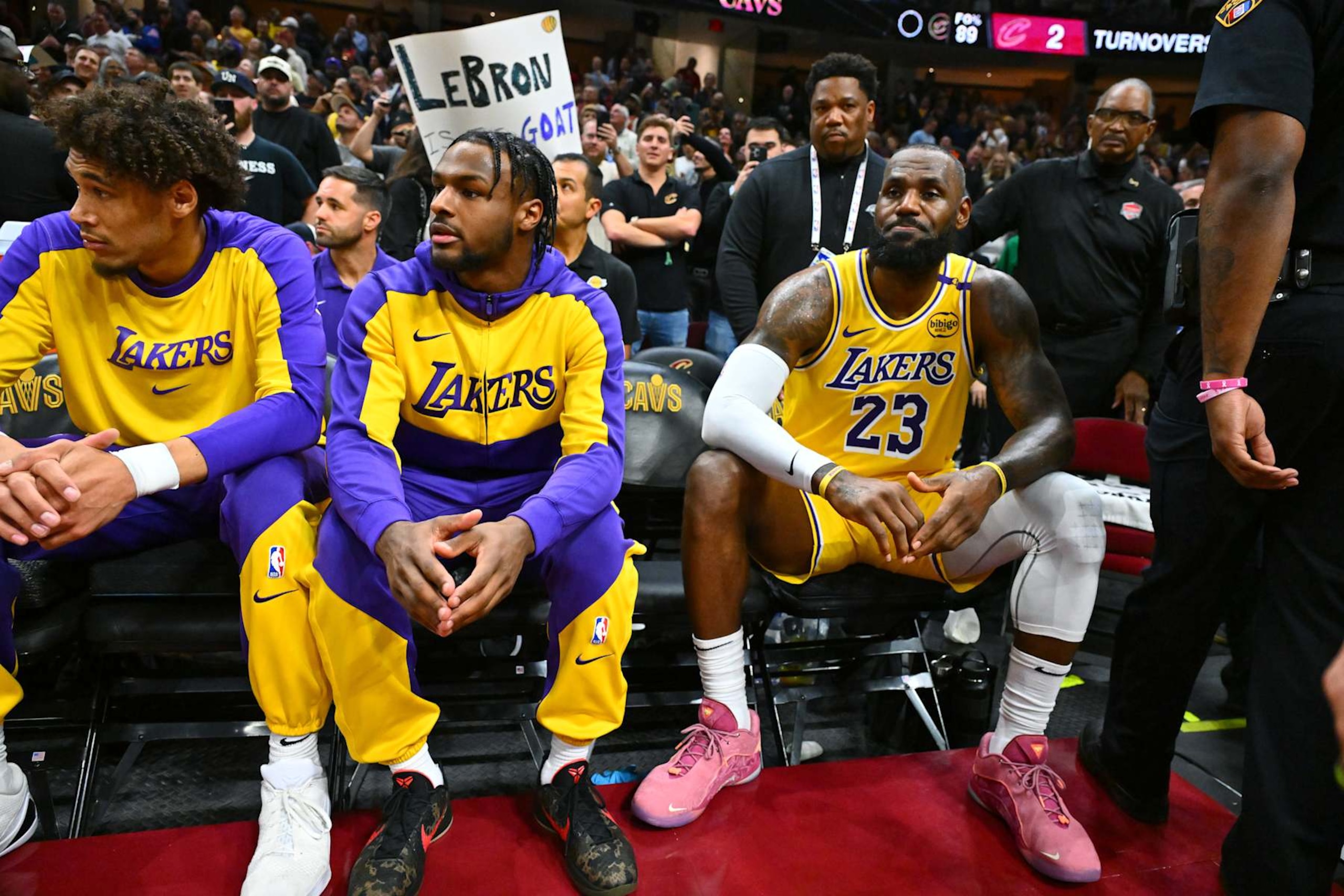CLEVELAND, OHIO - OCTOBER 30: Bronny James #9 sits with LeBron James #23 of the Los Angeles Lakers on the bench during the first half against the Cleveland Cavaliers at Rocket Mortgage Fieldhouse on October 30, 2024 in Cleveland, Ohio. NOTE TO USER: User expressly acknowledges and agrees that, by downloading and or using this photograph, User is consenting to the terms and conditions of the Getty Images License Agreement. (Photo by Jason Miller/Getty Images)