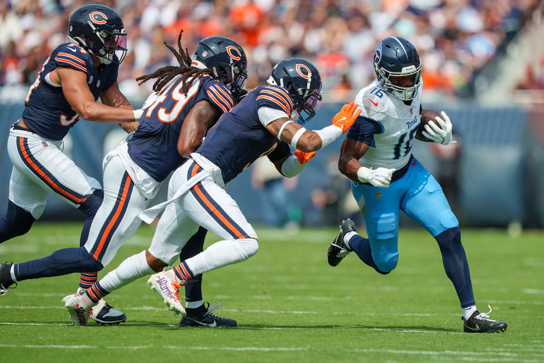 CHICAGO, ILLINOIS - SEPTEMBER 8: Wide receiver Treylon Burks #16 of the Tennessee Titans runs with the ball while being pursued by defensive lineman Austin Booker #94 of the Chicago Bears, linebacker Tremaine Edmunds #49 and safety Jaquan Brisker #9 during the first half of an NFL football game at Soldier Field on September 8, 2024 in Chicago, Illinois. (Photo by Todd Rosenberg/Getty Images)