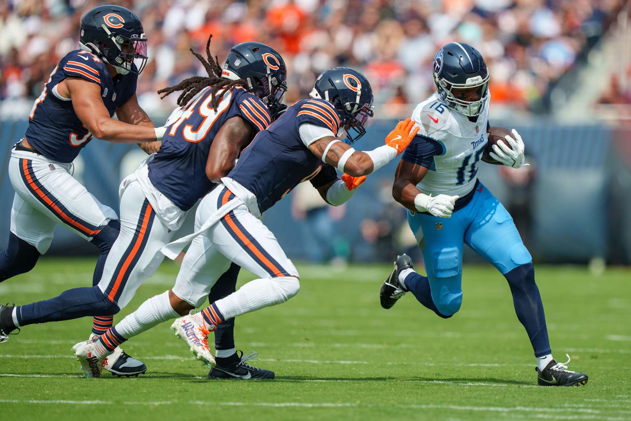 CHICAGO, ILLINOIS - SEPTEMBER 8: Wide receiver Treylon Burks #16 of the Tennessee Titans runs with the ball while being pursued by defensive lineman Austin Booker #94 of the Chicago Bears, linebacker Tremaine Edmunds #49 and safety Jaquan Brisker #9 during the first half of an NFL football game at Soldier Field on September 8, 2024 in Chicago, Illinois. (Photo by Todd Rosenberg/Getty Images)
