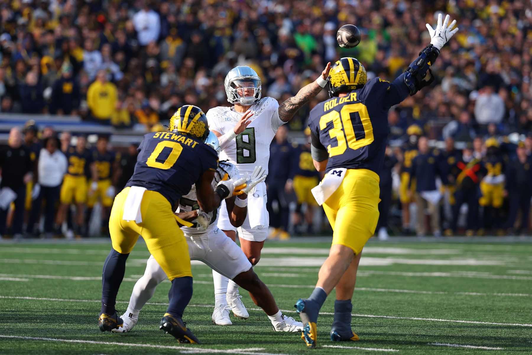 ANN ARBOR, MICHIGAN - NOVEMBER 02: Dillon Gabriel #8 of the Oregon Ducks throws the ball over Jimmy Rolder #30 of the Michigan Wolverines for a touchdown during the first quarter at Michigan Stadium on November 02, 2024 in Ann Arbor, Michigan. (Photo by Gregory Shamus/Getty Images)