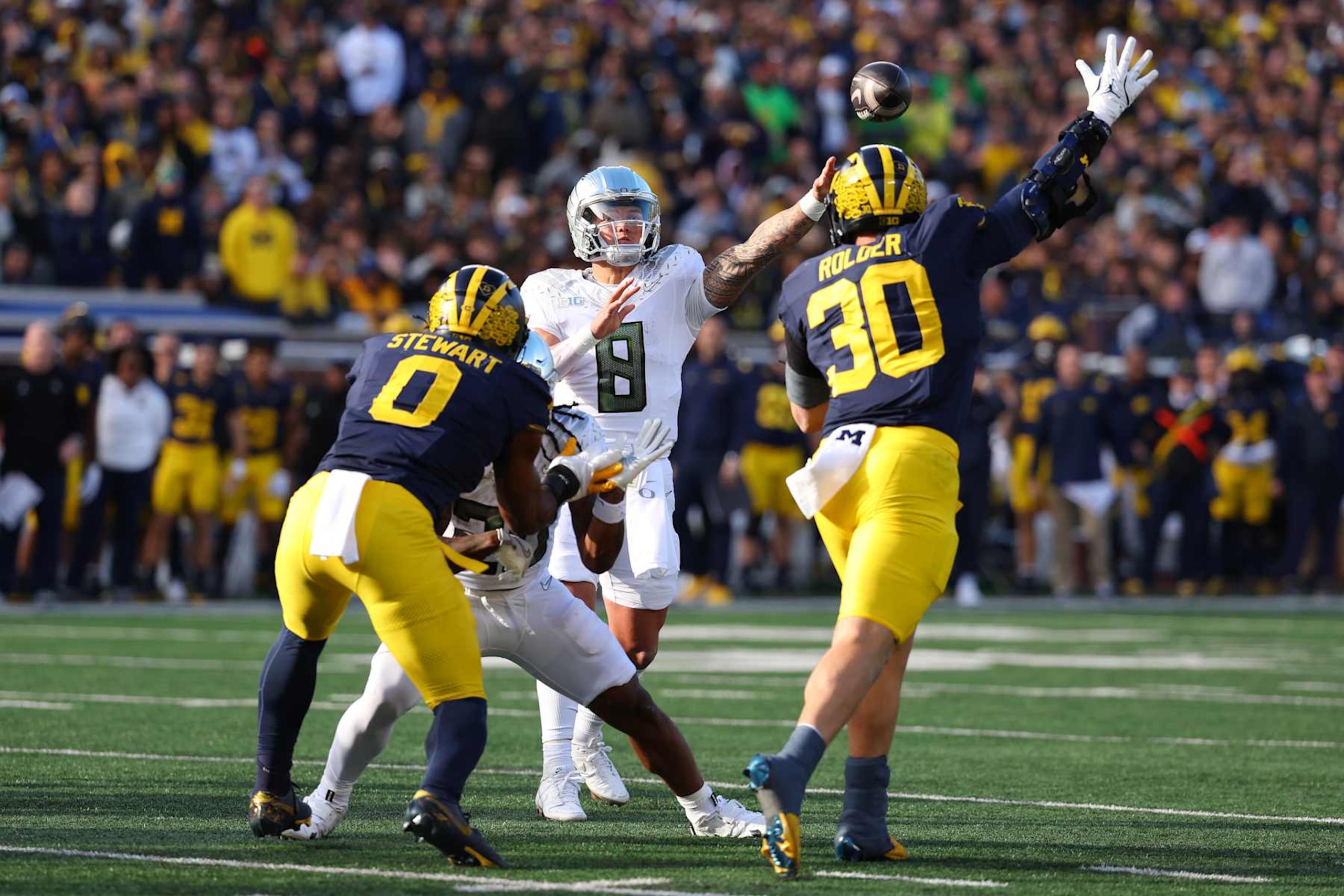 ANN ARBOR, MICHIGAN - NOVEMBER 02: Dillon Gabriel #8 of the Oregon Ducks throws the ball over Jimmy Rolder #30 of the Michigan Wolverines for a touchdown during the first quarter at Michigan Stadium on November 02, 2024 in Ann Arbor, Michigan. (Photo by Gregory Shamus/Getty Images)