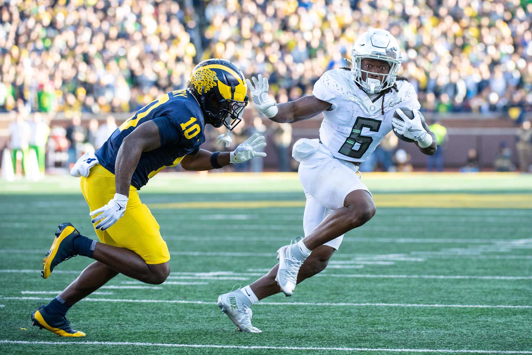 ANN ARBOR, MICHIGAN - NOVEMBER 02: Noah Whittington #6 of the Oregon Ducks runs with the ball for yardage against Zeke Berry #10 of the Michigan Wolverines during the first half of a college football game at Michigan Stadium on November 02, 2024 in Ann Arbor, Michigan. (Photo by Aaron J. Thornton/Getty Images)