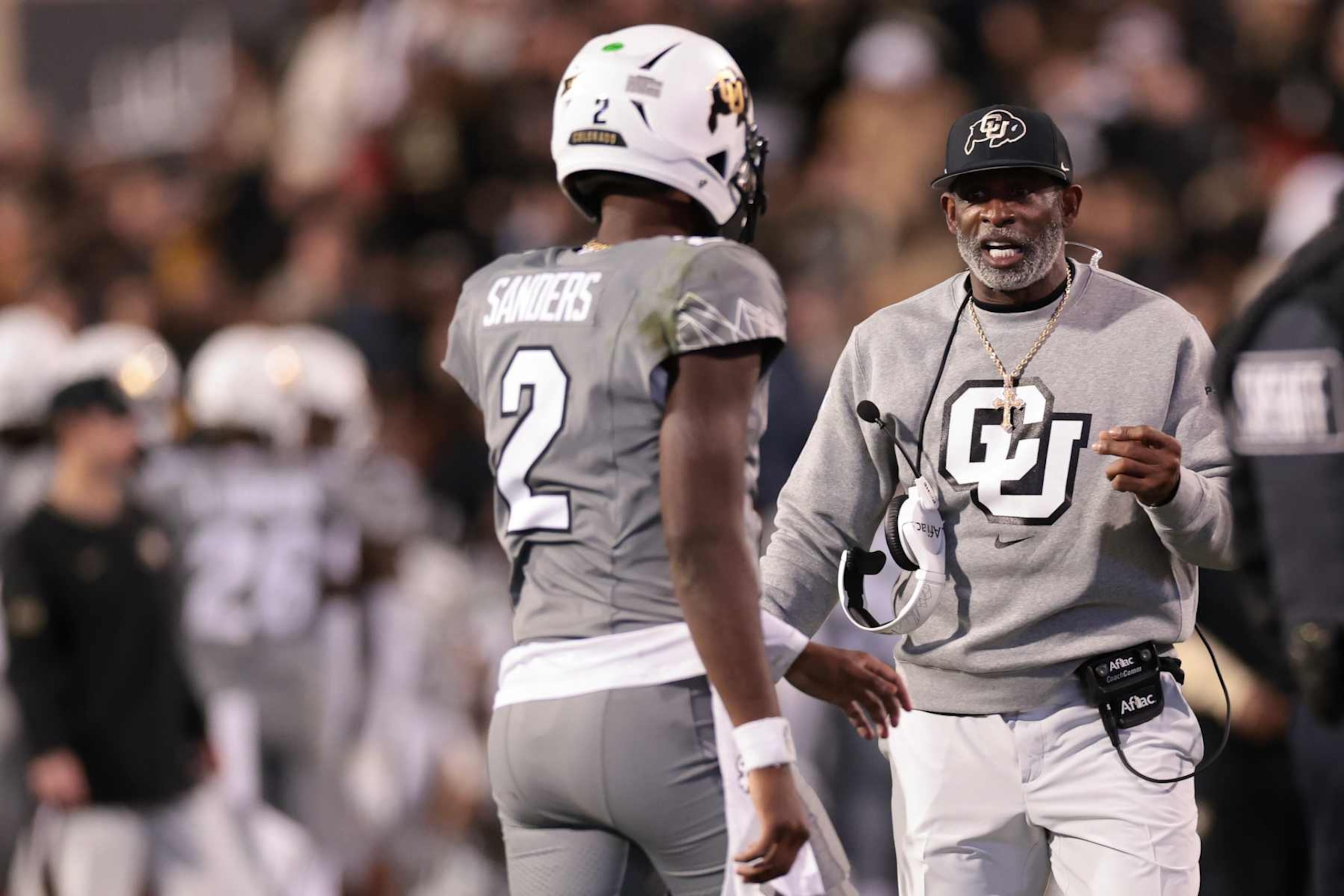 Shedeur Sanders talks with Head coach Deion Sanders of the Colorado Buffaloes