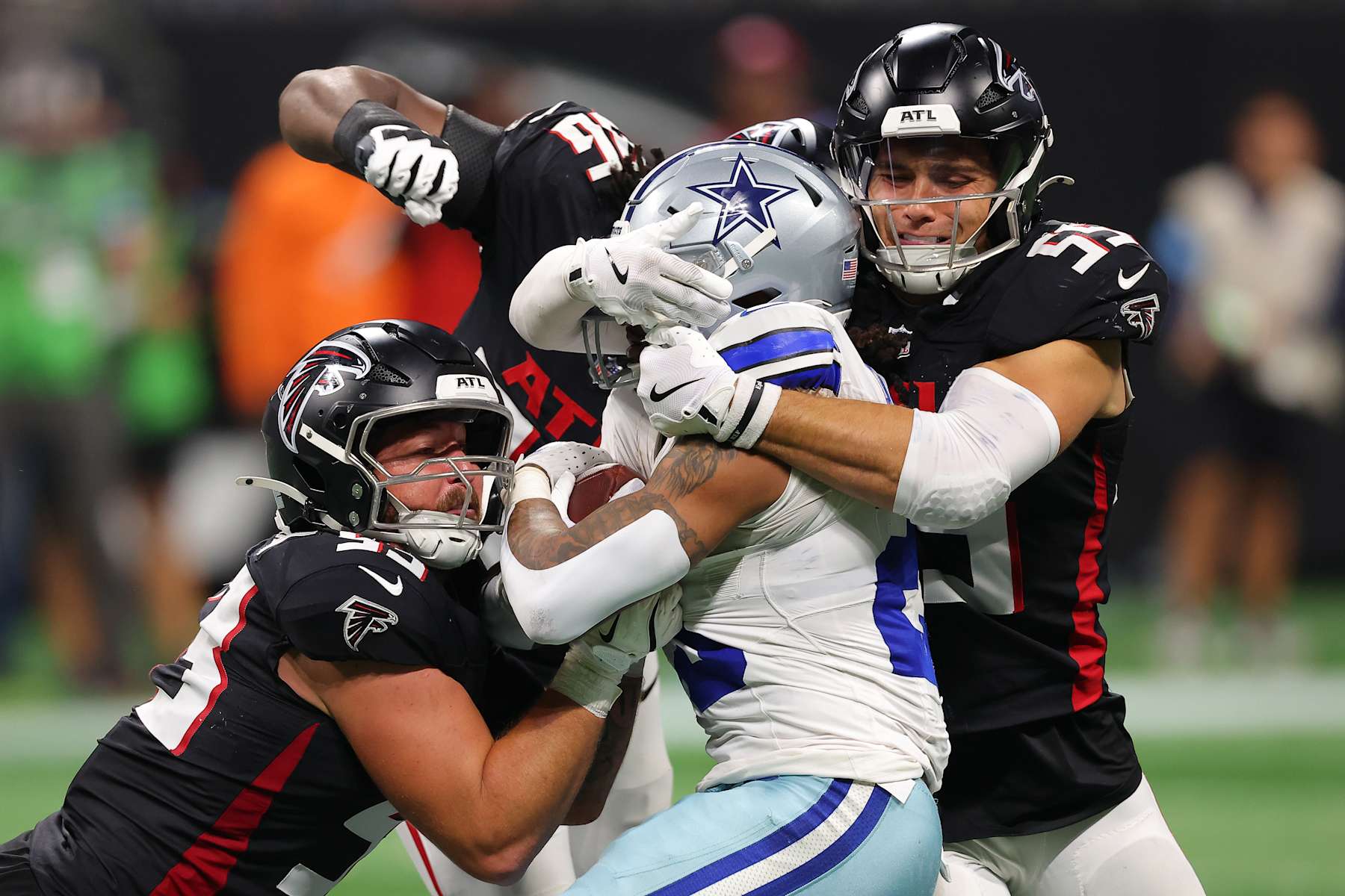 ATLANTA, GEORGIA - NOVEMBER 03: Rico Dowdle #23 of the Dallas Cowboys is tackled by Nate Landman #53 and Kaden Elliss #55 of the Atlanta Falcons during the fourth quarter at Mercedes-Benz Stadium on November 03, 2024 in Atlanta, Georgia. (Photo by Kevin C. Cox/Getty Images)