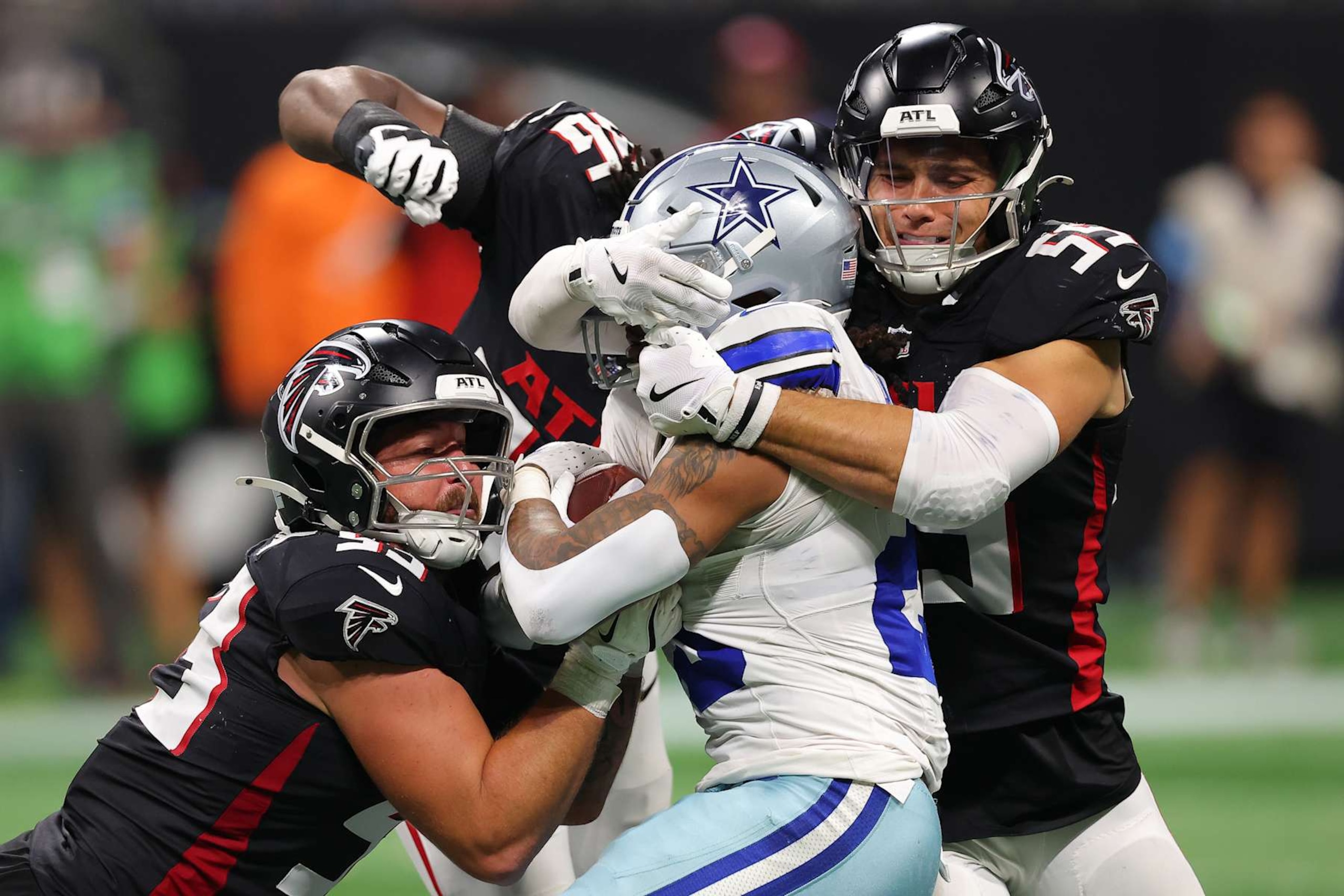 ATLANTA, GEORGIA - NOVEMBER 03: Rico Dowdle #23 of the Dallas Cowboys is tackled by Nate Landman #53 and Kaden Elliss #55 of the Atlanta Falcons during the fourth quarter at Mercedes-Benz Stadium on November 03, 2024 in Atlanta, Georgia. (Photo by Kevin C. Cox/Getty Images)
