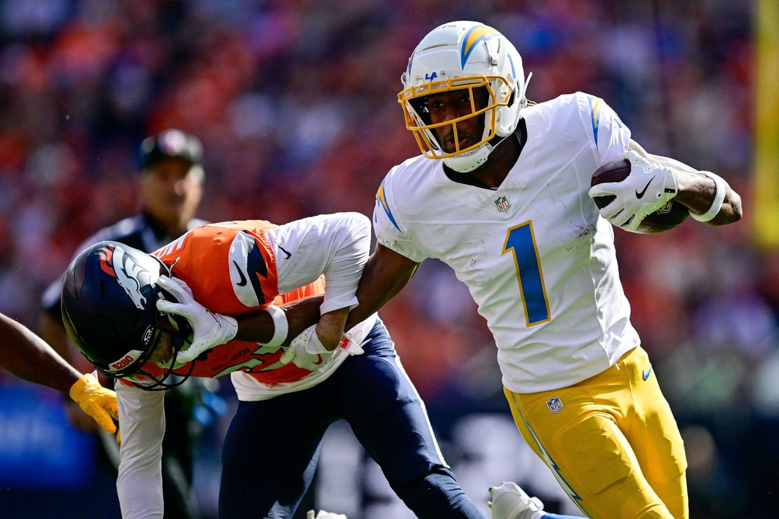 DENVER, COLORADO - OCTOBER 13:  Quentin Johnston #1 of the Los Angeles Chargers runs against Riley Moss #21 of the Denver Broncos after a reception in the first quarter at Empower Field at Mile High on October 13, 2024 in Denver, Colorado. (Photo by Dustin Bradford/Getty Images)
