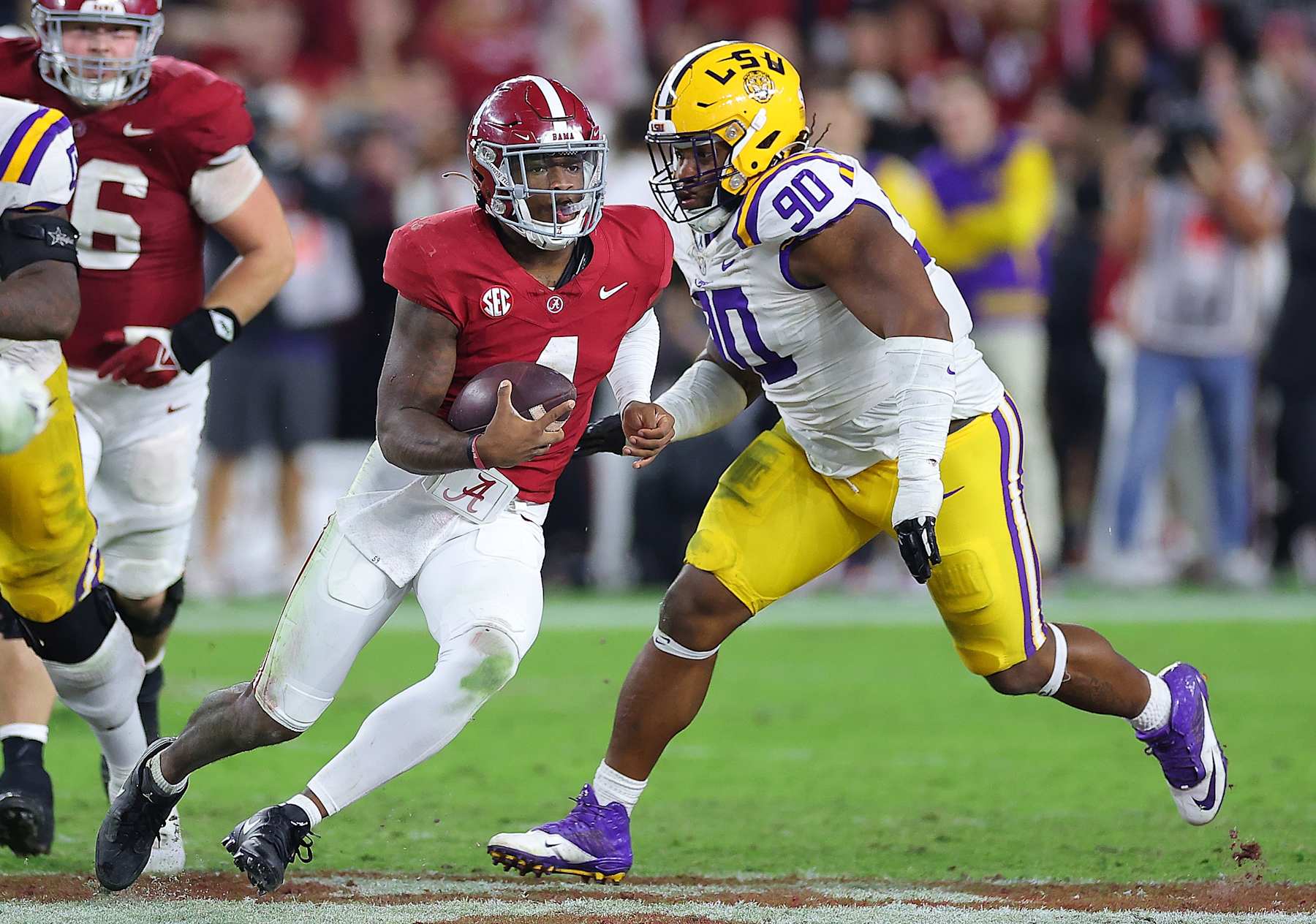 TUSCALOOSA, ALABAMA - NOVEMBER 04:  Jalen Milroe #4 of the Alabama Crimson Tide rushes away from Jacobian Guillory #90 of the LSU Tigers during the fourth quarter at Bryant-Denny Stadium on November 04, 2023 in Tuscaloosa, Alabama.  (Photo by Kevin C. Cox/Getty Images)