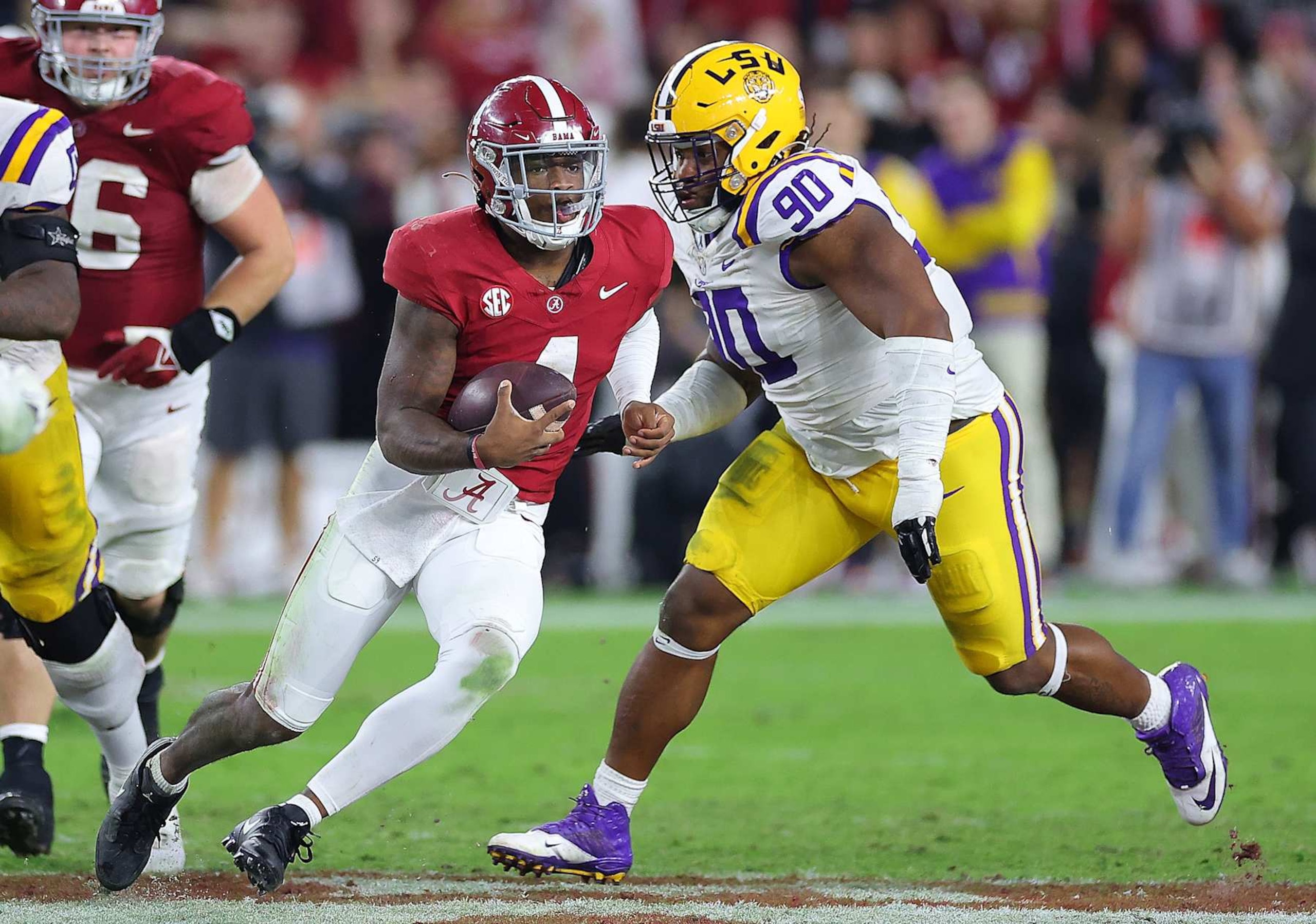 TUSCALOOSA, ALABAMA - NOVEMBER 04:  Jalen Milroe #4 of the Alabama Crimson Tide rushes away from Jacobian Guillory #90 of the LSU Tigers during the fourth quarter at Bryant-Denny Stadium on November 04, 2023 in Tuscaloosa, Alabama.  (Photo by Kevin C. Cox/Getty Images)