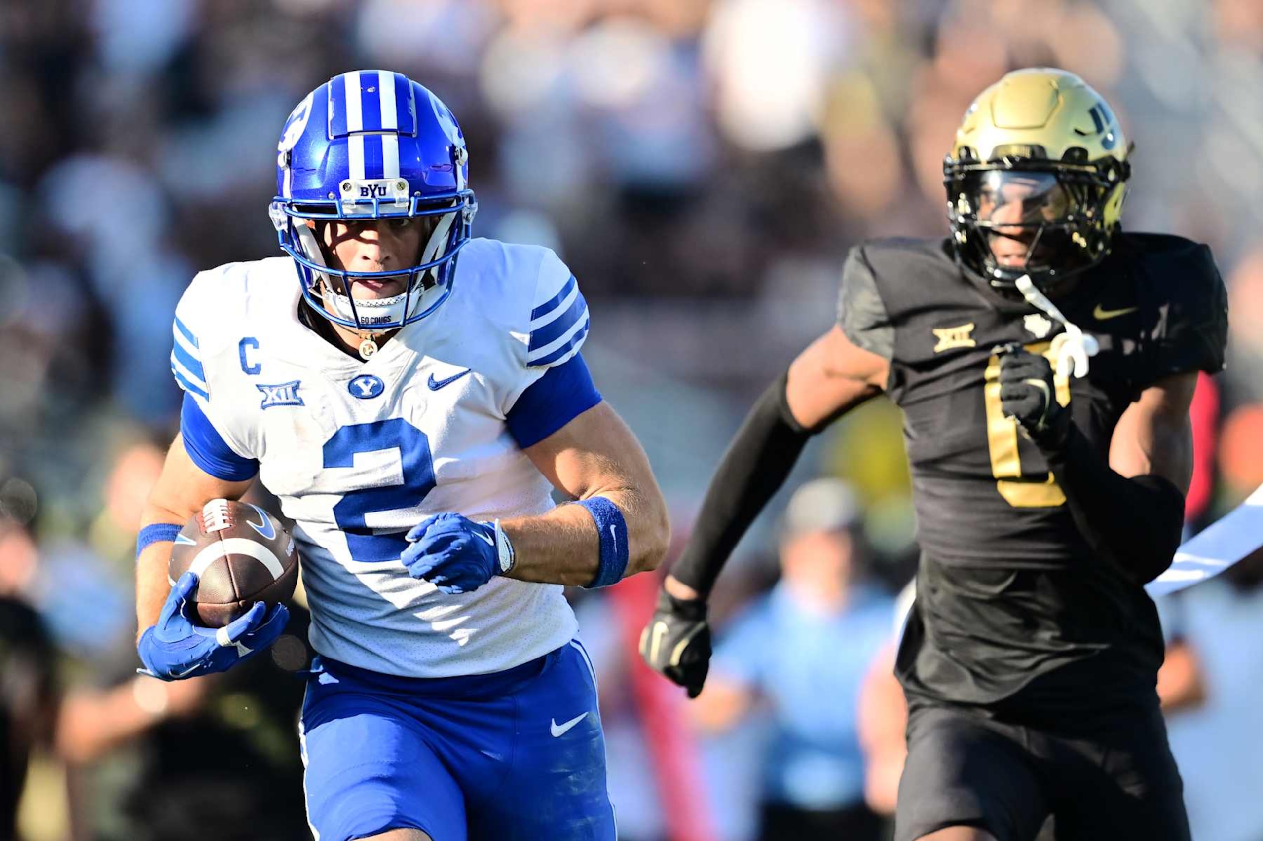 ORLANDO, FLORIDA - OCTOBER 26: Chase Roberts #2 of the Brigham Young Cougars scores a touchdown on a 62-yard pass in front of Brandon Adams #0 of the UCF Knights in the first half of a game at FBC Mortgage Stadium on October 26, 2024 in Orlando, Florida. (Photo by Julio Aguilar/Getty Images)