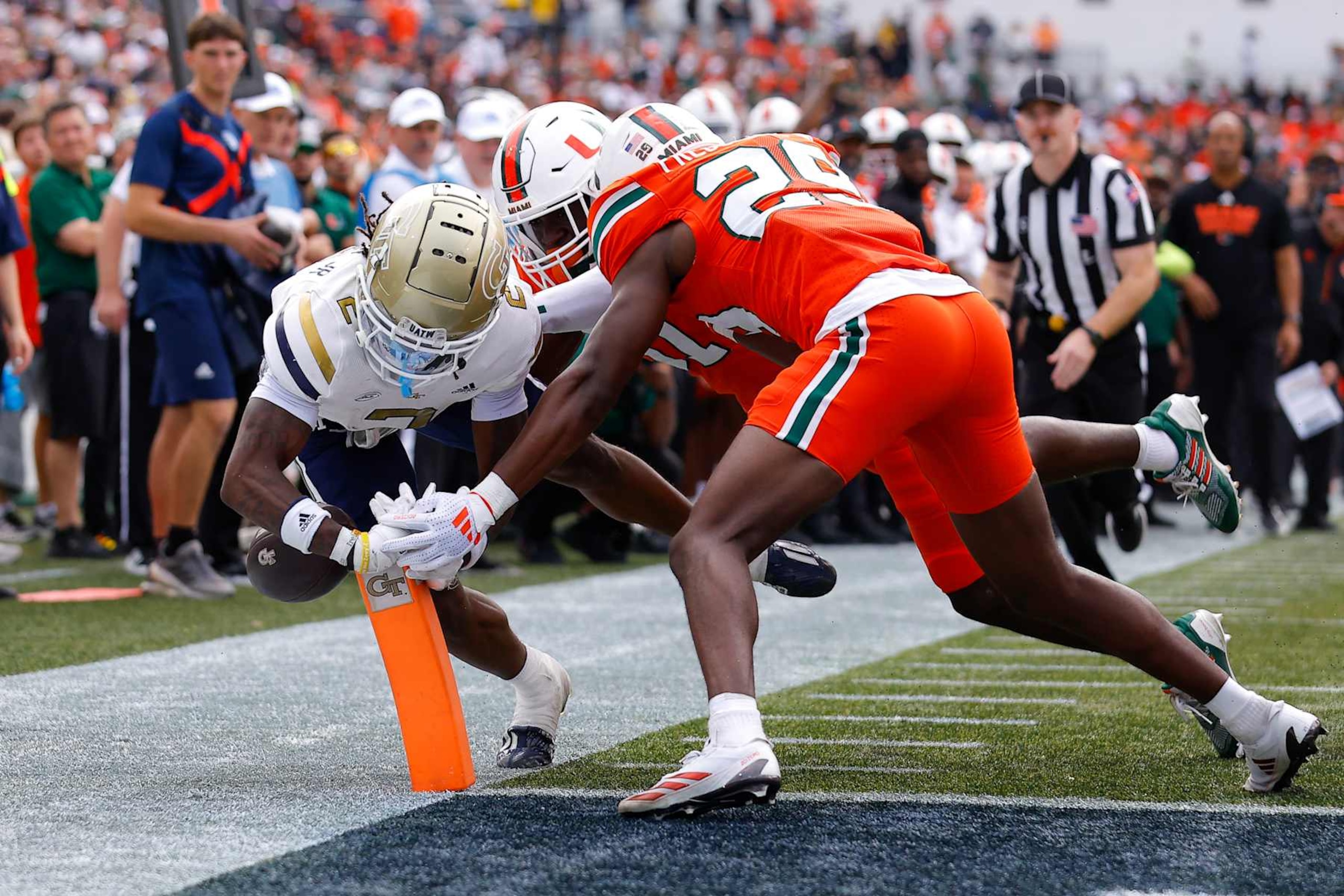 ATLANTA, GEORGIA - NOVEMBER 9: Eric Singleton Jr. #2 of the Georgia Tech Yellow Jackets is knocked out of bounds by OJ Frederique Jr. #29 and Wesley Bissainthe #31 of the Miami Hurricanes during the second quarter at Bobby Dodd Stadium on November 9, 2024 in Atlanta, Georgia. (Photo by Todd Kirkland/Getty Images)