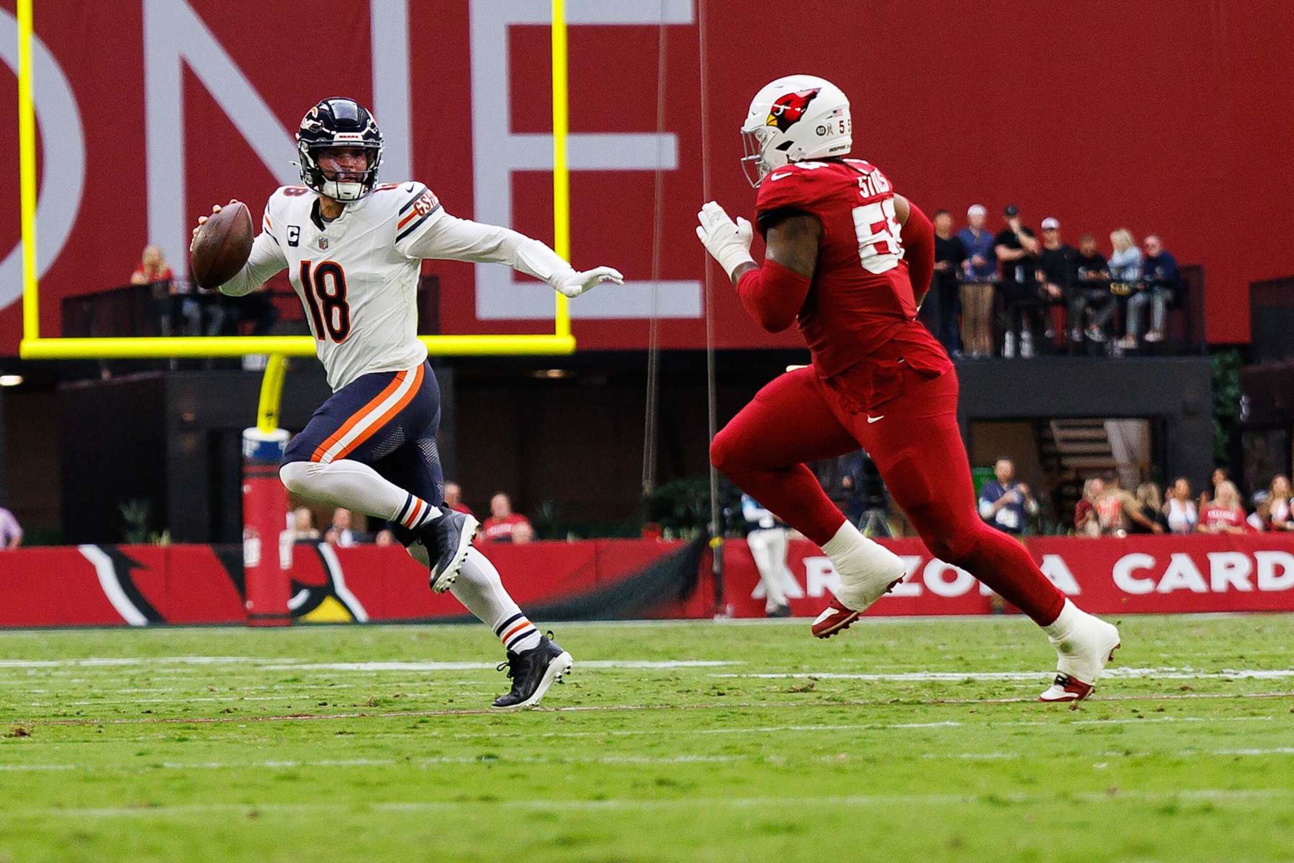 GLENDALE, ARIZONA - NOVEMBER 3: Quarterback Caleb Williams #18 of the Chicago Bears scrambles out of the pocket against Arizona Cardinals defensive tackle Dante Stills (55) during the second quarter of an NFL football game, at State Farm Stadium on November 3, 2024 in Glendale, Arizona. (Photo by Brooke Sutton/Getty Images)