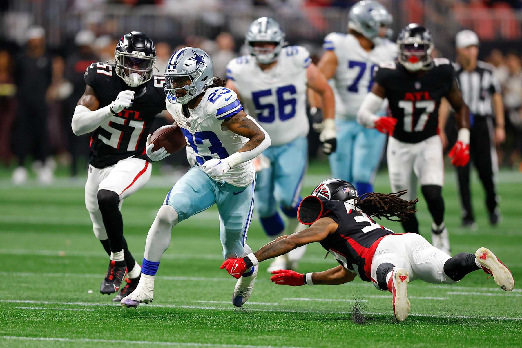 ATLANTA, GEORGIA - NOVEMBER 3: Rico Dowdle #23 of the Dallas Cowboys rushes as Kevin King #32 of the Atlanta Falcons attempts a tackle during the fourth quarter at Mercedes-Benz Stadium on November 3, 2024 in Atlanta, Georgia. (Photo by Todd Kirkland/Getty Images)