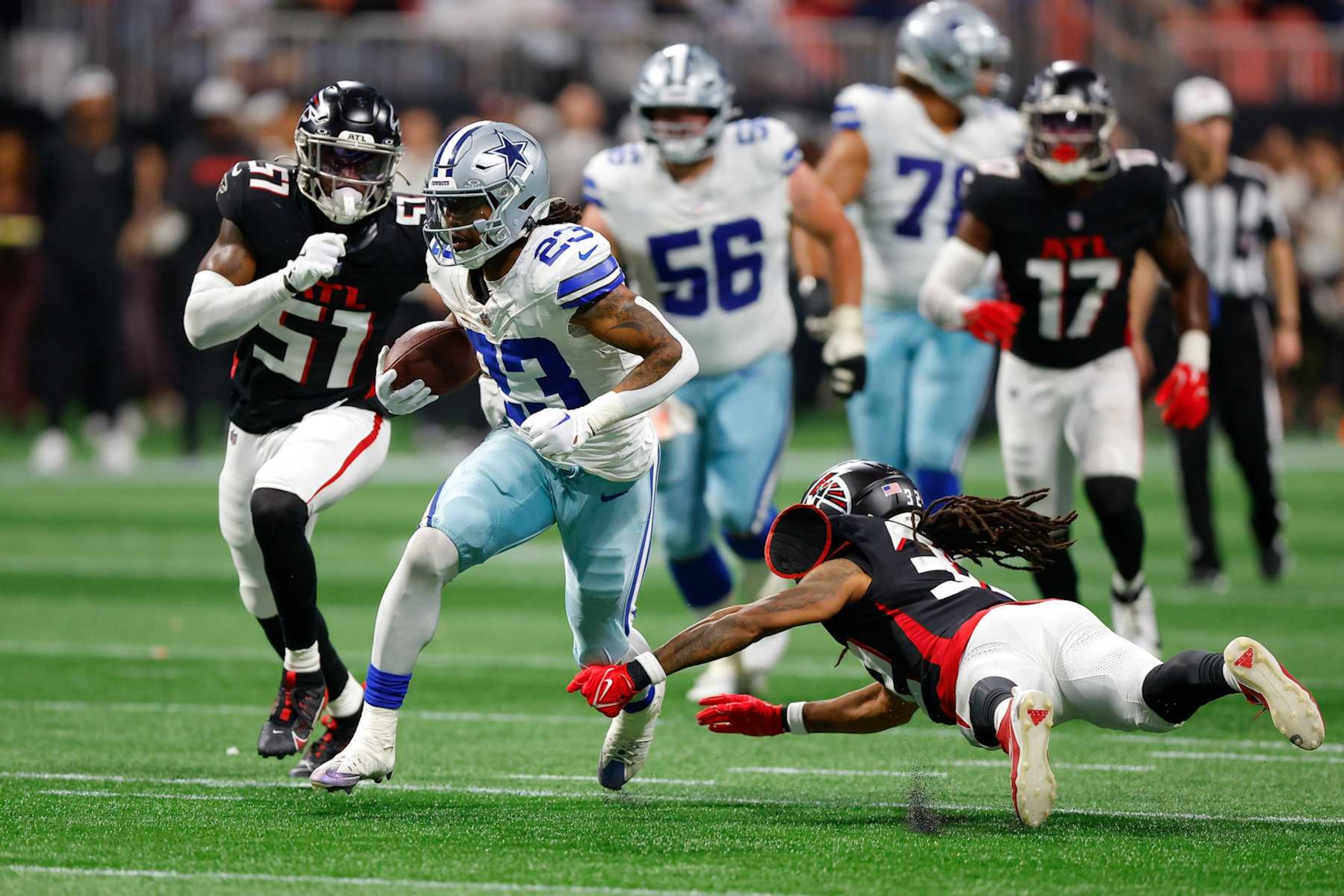 ATLANTA, GEORGIA - NOVEMBER 3: Rico Dowdle #23 of the Dallas Cowboys rushes as Kevin King #32 of the Atlanta Falcons attempts a tackle during the fourth quarter at Mercedes-Benz Stadium on November 3, 2024 in Atlanta, Georgia. (Photo by Todd Kirkland/Getty Images)