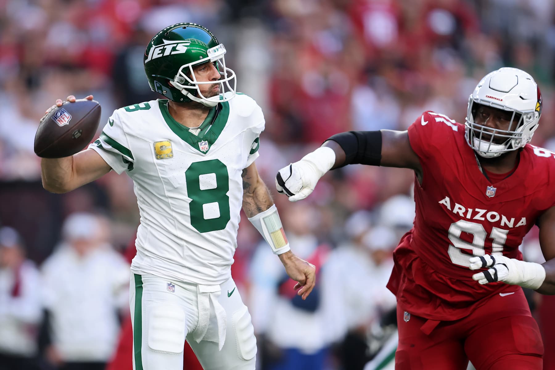GLENDALE, ARIZONA - NOVEMBER 10: Aaron Rodgers #8 of the New York Jets throws a pass while being pressured by L.J. Collier #91 of the Arizona Cardinals in the second quarter at State Farm Stadium on November 10, 2024 in Glendale, Arizona. (Photo by Chris Coduto/Getty Images)