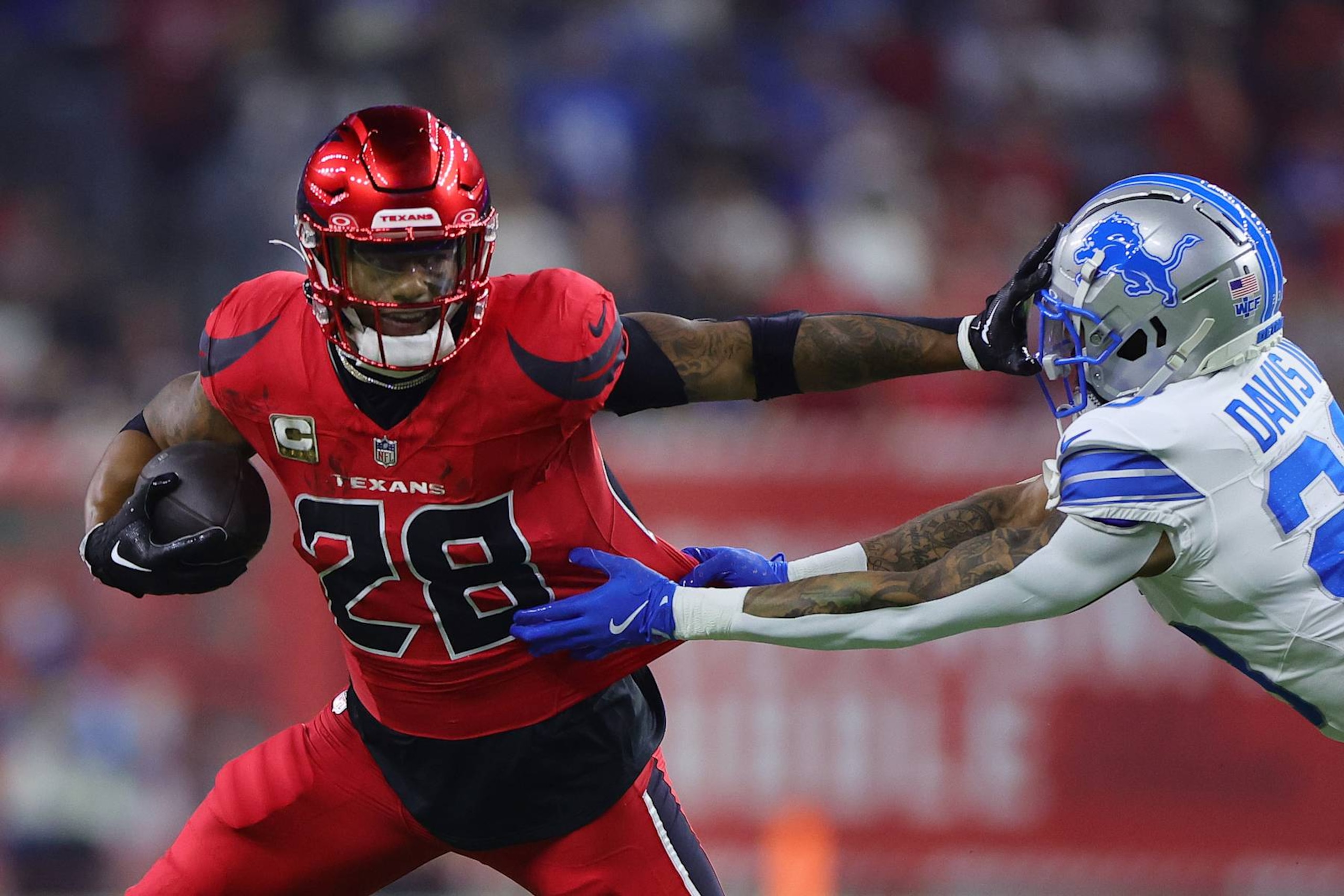 HOUSTON, TEXAS - NOVEMBER 10: Joe Mixon #28 of the Houston Texans stiff arms Carlton Davis III #23 of the Detroit Lions during the first quarter at NRG Stadium on November 10, 2024 in Houston, Texas. (Photo by Alex Slitz/Getty Images)