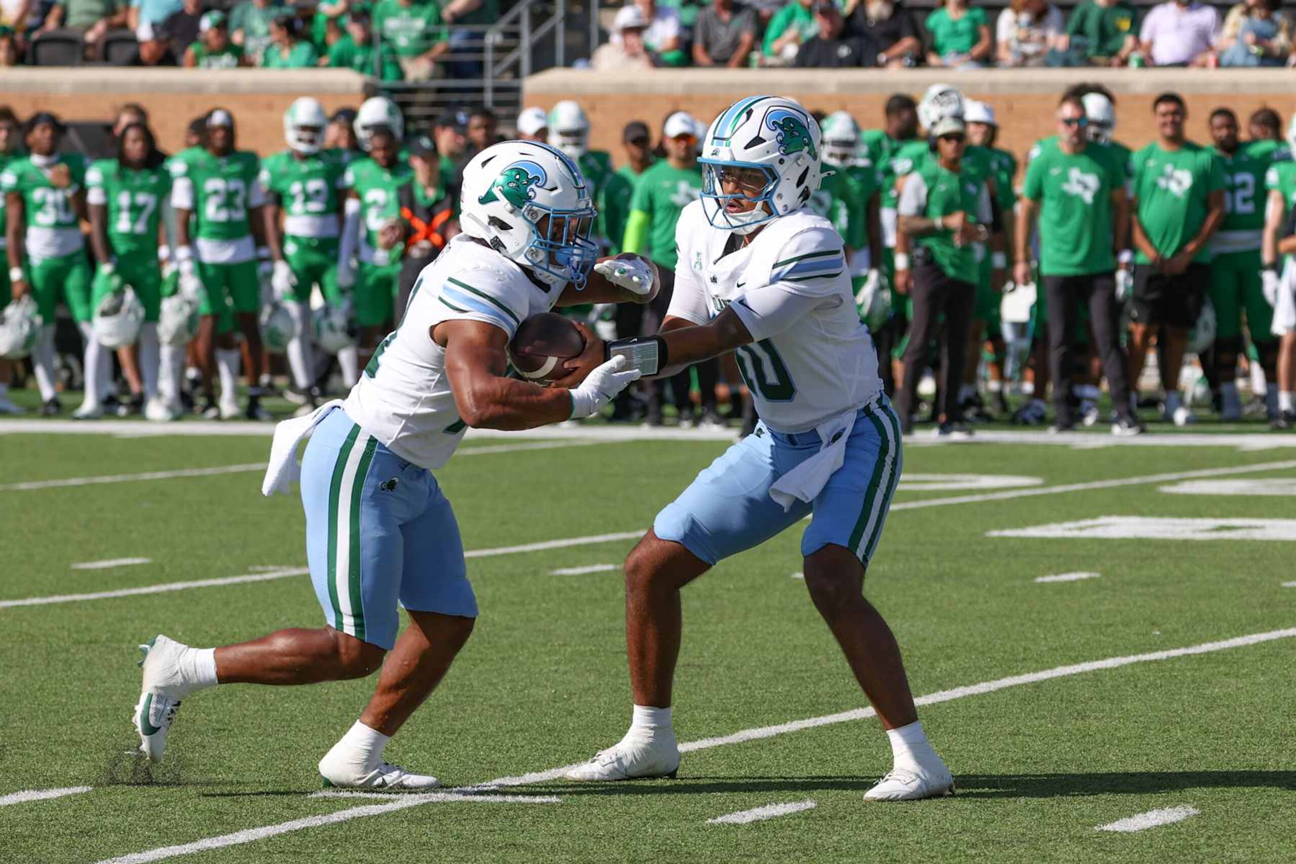 DENTON, TX - OCTOBER 26: Tulane Green Wave quarterback Darian Mensah (10) hands off to Tulane Green Wave running back Arnold Barnes III (20) during the game between North Texas and Tulane on October 26, 2024 at DATCU Stadium in Denton, TX. (Photo by George Walker/Icon Sportswire via Getty Images) DENTON, TX - OCTOBER 26: Tulane Green Wave quarterback Darian Mensah (10) hands off to Tulane Green Wave running back Arnold Barnes III (20) during the game between North Texas and Tulane on October 26, 2024 at DATCU Stadium in Denton, TX. (Photo by George Walker/Icon Sportswire via Getty Images)