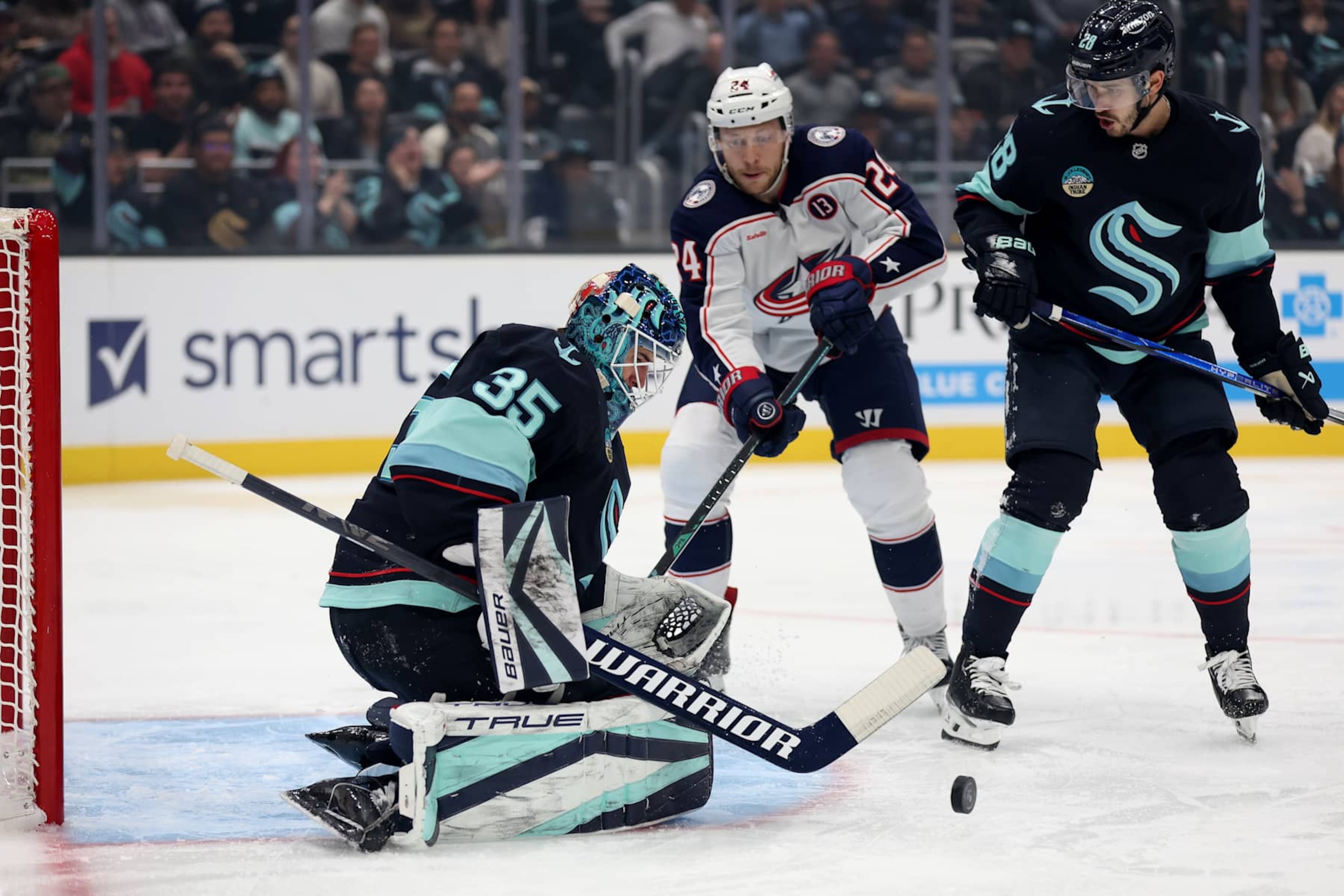 SEATTLE, WASHINGTON - NOVEMBER 12: Joey Daccord #35 of the Seattle Kraken makes a save next to Mathieu Olivier #24 of the Columbus Blue Jackets during the first period at Climate Pledge Arena on November 12, 2024 in Seattle, Washington. (Photo by Steph Chambers/Getty Images) SEATTLE, WASHINGTON - NOVEMBER 12: Joey Daccord #35 of the Seattle Kraken makes a save next to Mathieu Olivier #24 of the Columbus Blue Jackets during the first period at Climate Pledge Arena on November 12, 2024 in Seattle, Washington. (Photo by Steph Chambers/Getty Images)