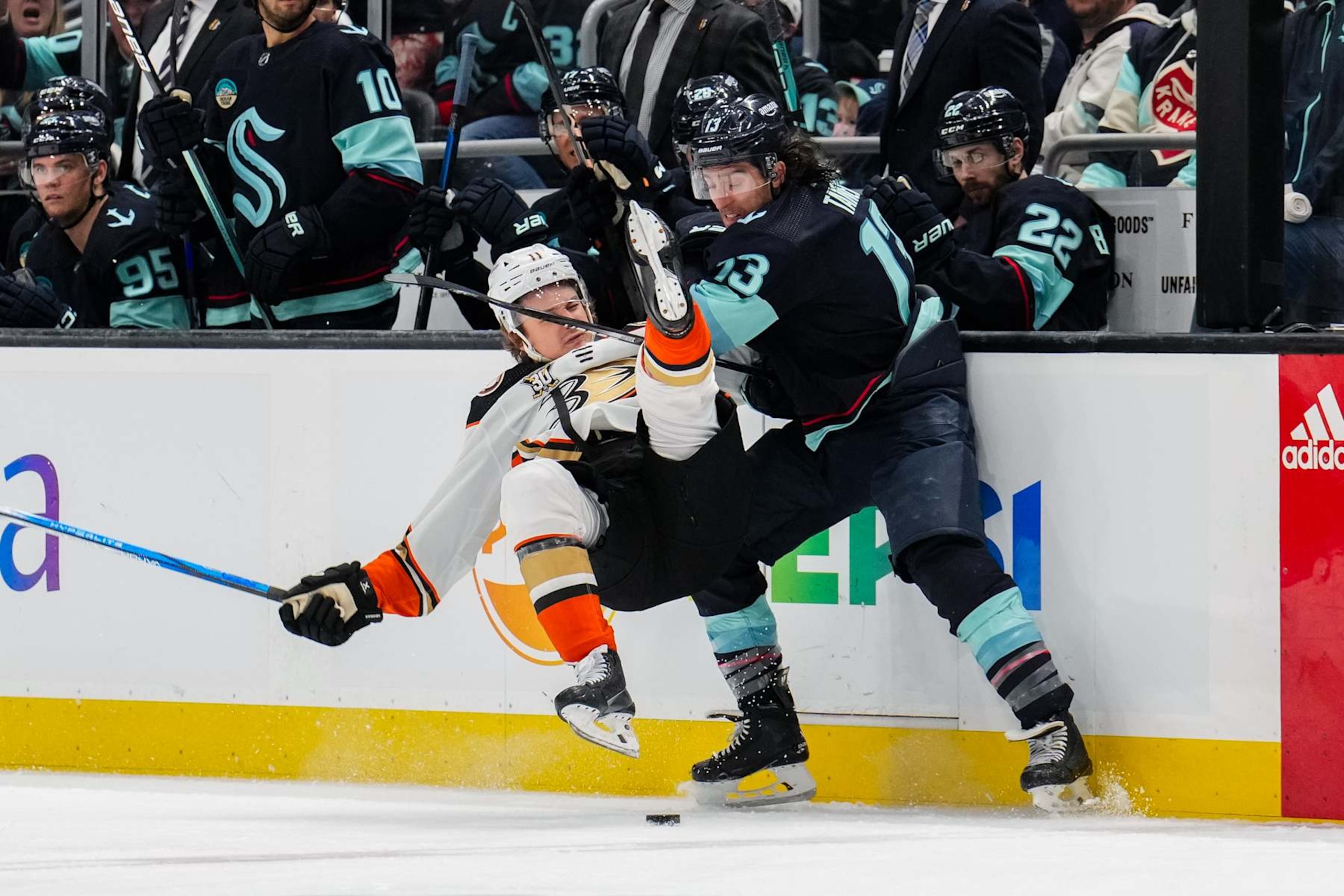 Seattle Kraken forward Brandon Tanev (right) checks Anaheim Ducks forward Trevor Zegras.