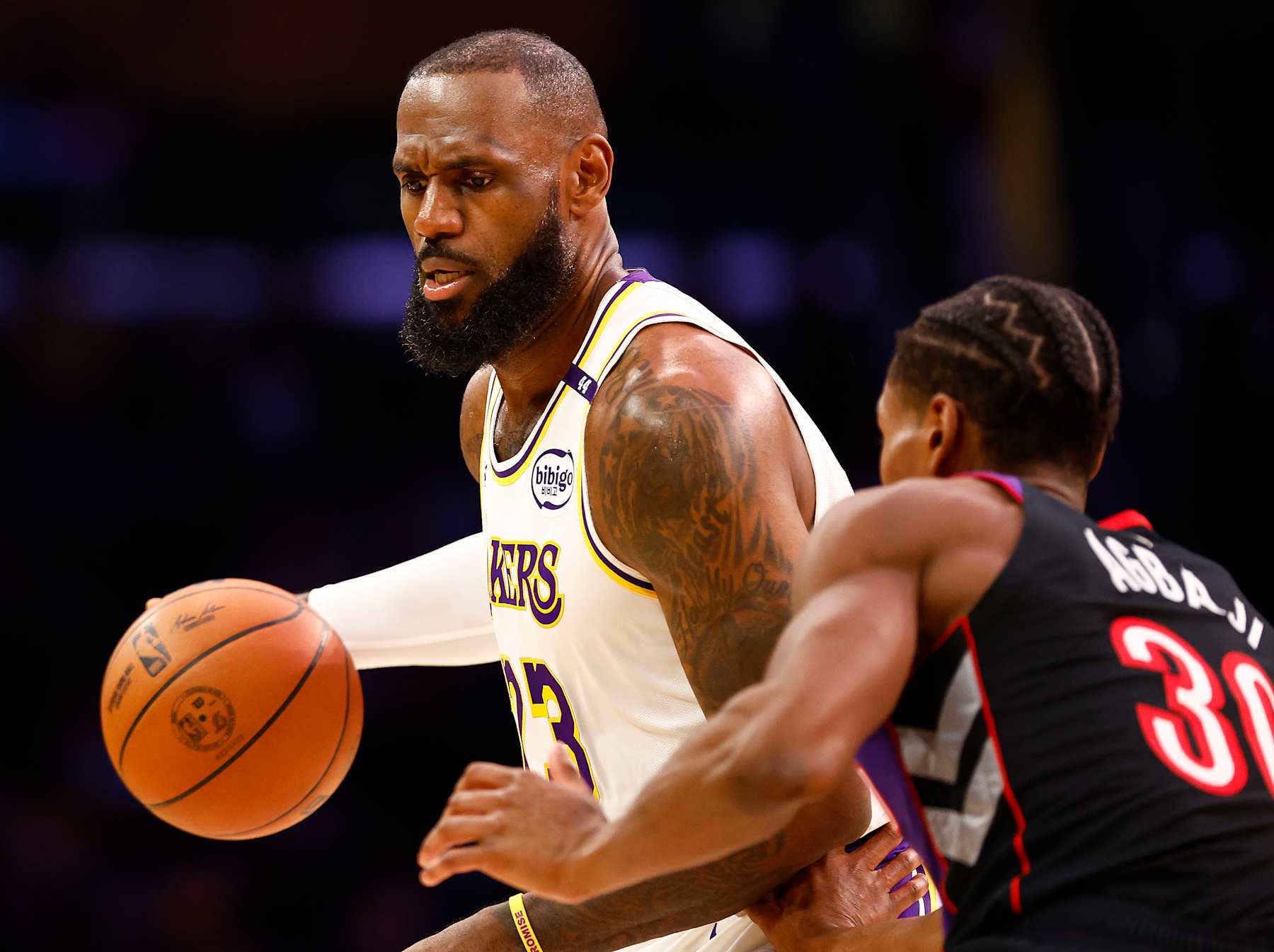 LOS ANGELES, CALIFORNIA - NOVEMBER 10:  LeBron James #23 of the Los Angeles Lakers controls the ball against Ochai Agbaji #30 of the Toronto Raptors in the first half at Crypto.com Arena on November 10, 2024 in Los Angeles, California.  NOTE TO USER: User expressly acknowledges and agrees that, by downloading and/or using this photograph, user is consenting to the terms and conditions of the Getty Images License Agreement. (Photo by Ronald Martinez/Getty Images)