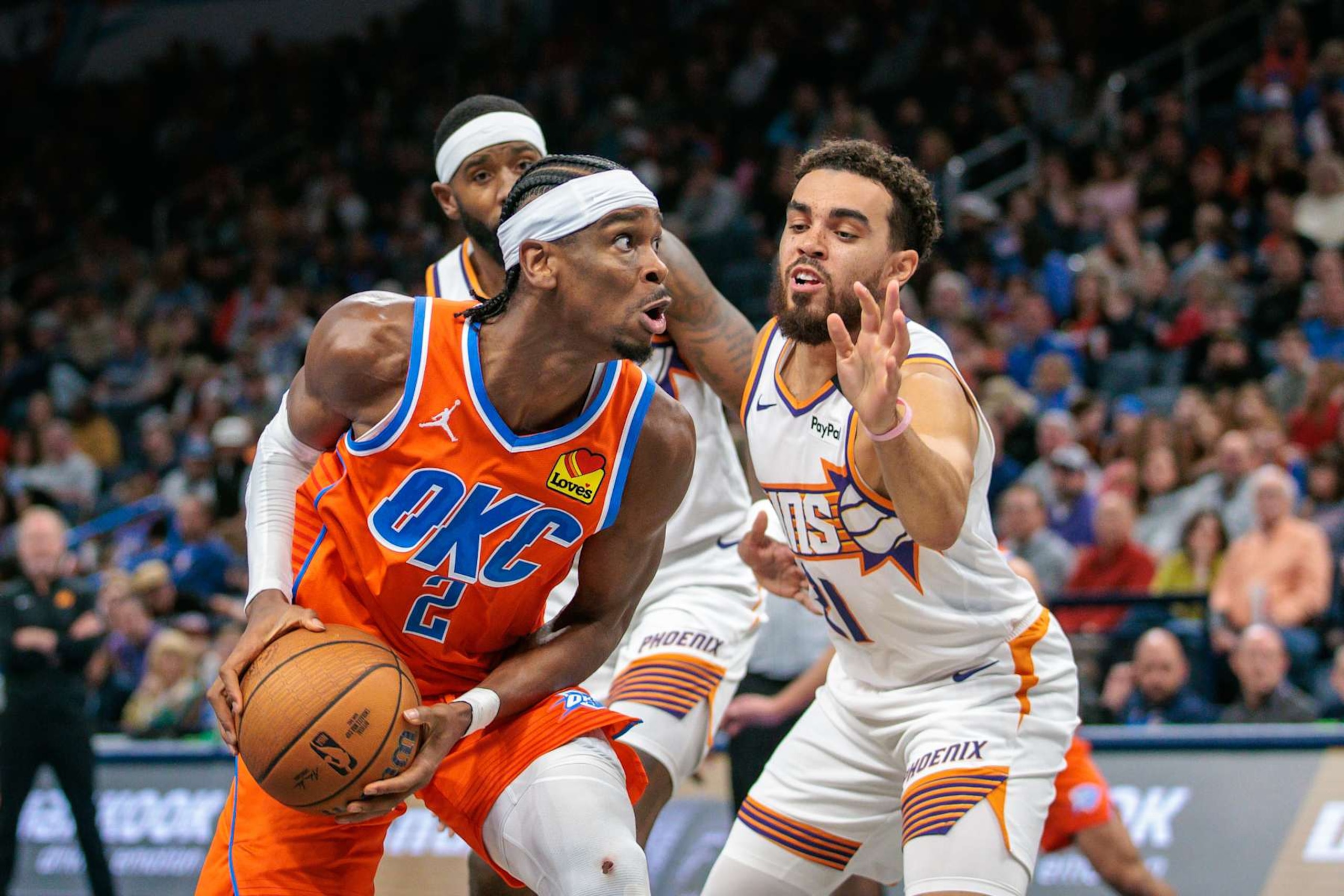 OKLAHOMA CITY, OKLAHOMA - NOVEMBER 15: Shai Gilgeous-Alexander #2 of the Oklahoma City Thunder drives around Tyus Jones #21 of the Phoenix Suns during the third quarter of the Emirates NBA Cup game at Paycom Center on November 15, 2024 in Oklahoma City, Oklahoma. NOTE TO USER: User expressly acknowledges and agrees that, by downloading and or using this photograph, User is consenting to the terms and conditions of the Getty Images License Agreement. (Photo by William Purnell/Getty Images) OKLAHOMA CITY, OKLAHOMA - NOVEMBER 15: Shai Gilgeous-Alexander #2 of the Oklahoma City Thunder drives around Tyus Jones #21 of the Phoenix Suns during the third quarter of the Emirates NBA Cup game at Paycom Center on November 15, 2024 in Oklahoma City, Oklahoma. NOTE TO USER: User expressly acknowledges and agrees that, by downloading and or using this photograph, User is consenting to the terms and conditions of the Getty Images License Agreement. (Photo by William Purnell/Getty Images)