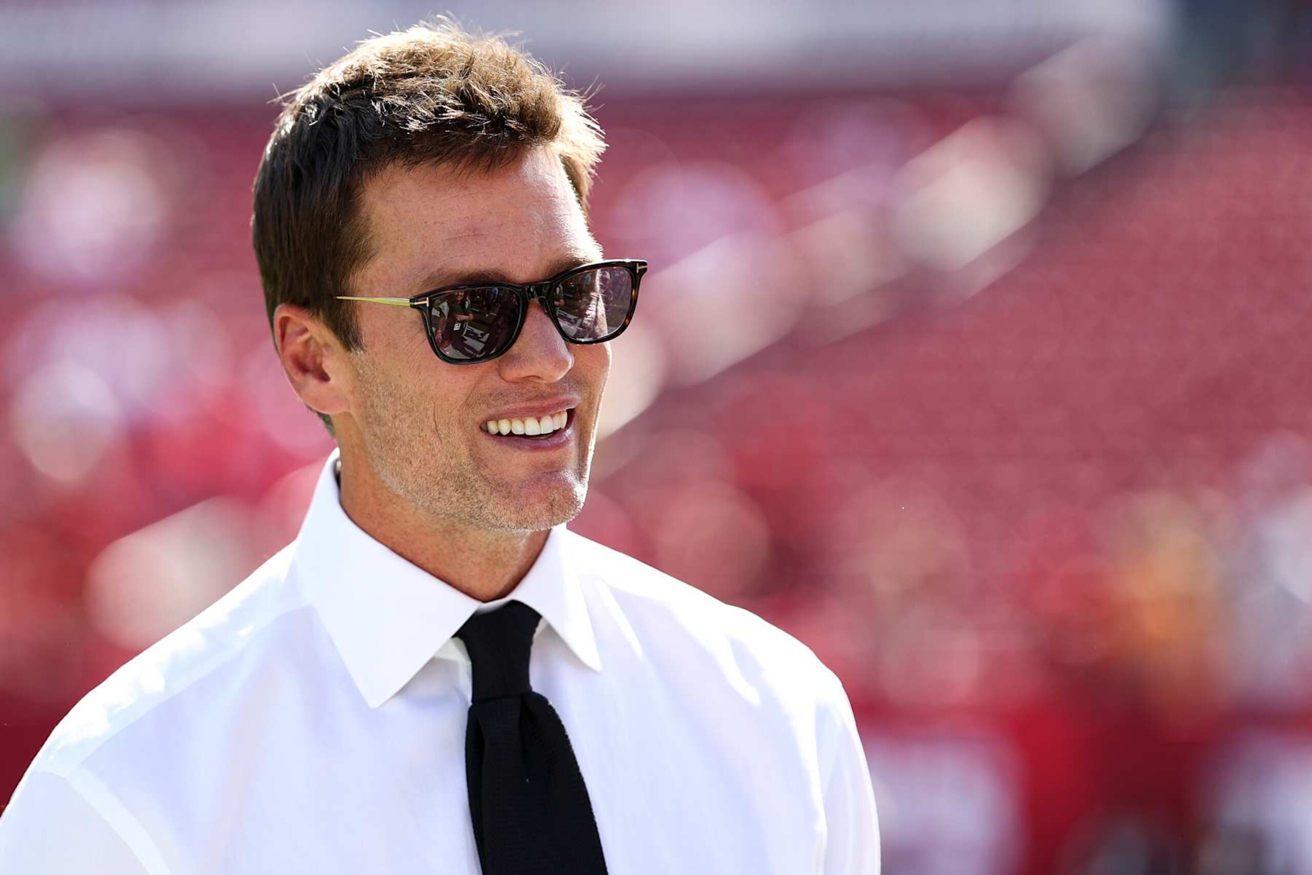 TAMPA, FLORIDA - NOVEMBER 10: Fox Sports commentator and former quarterback Tom Brady smiles on the field prior to an NFL football game between the Tampa Bay Buccaneers and the San Francisco 49ers at Raymond James Stadium on November 10, 2024 in Tampa, Florida. (Photo by Kevin Sabitus/Getty Images)