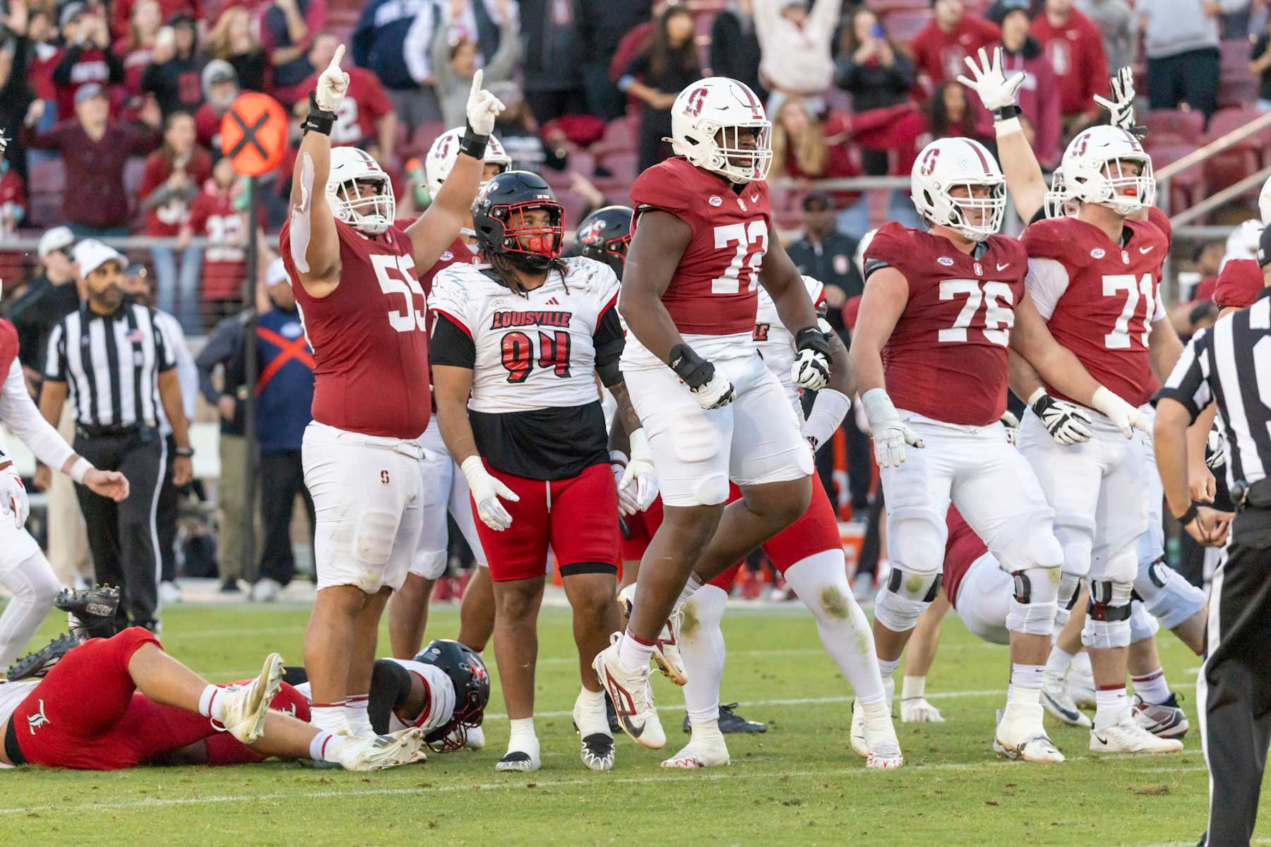 PALO ALTO, CA - NOVEMBER 16:  Stanford Cardinal players including Simione Pale #55, Austin Uke #72, Jack Leyrer #76, and Connor McLaughlin #71 celebrate Emmet Kenney's 52 yard game-winning field goal at the end of  an ACC college football game against the Louisville Cardinals on November 16, 2024 at Stanford Stadium in Palo Alto, California.; Louisville players include Jordan Guerad #94.  (Photo by David Madison/Getty Images)