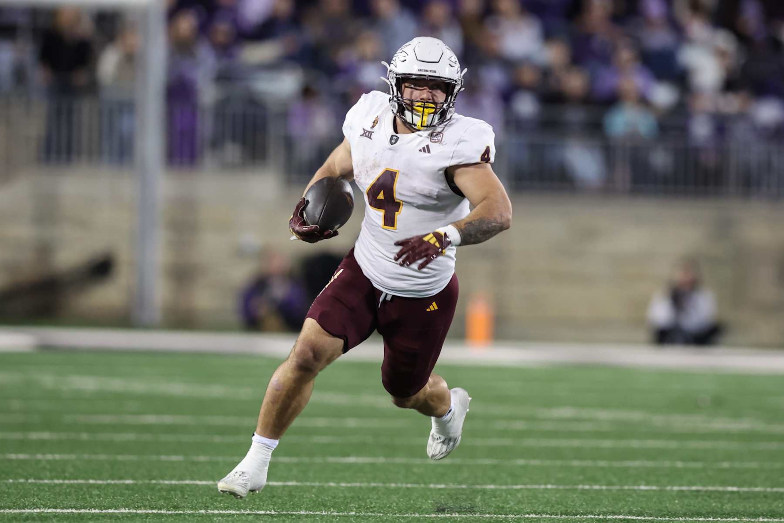 MANHATTAN, KS - NOVEMBER 16: Arizona State Sun Devils running back Cam Skattebo (4) run with the ball in the second quarter of a Big 12 game between the Arizona State Sun Devils and Kansas State Wildcats on November 16, 2024 at Bill Snyder Family Stadium in Manhattan, KS. (Photo by Scott Winters/Icon Sportswire via Getty Images) MANHATTAN, KS - NOVEMBER 16: Arizona State Sun Devils running back Cam Skattebo (4) run with the ball in the second quarter of a Big 12 game between the Arizona State Sun Devils and Kansas State Wildcats on November 16, 2024 at Bill Snyder Family Stadium in Manhattan, KS. (Photo by Scott Winters/Icon Sportswire via Getty Images)