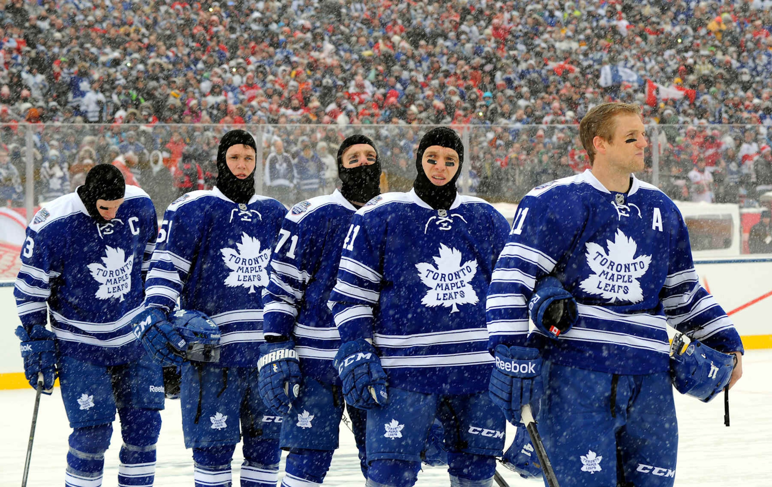 TORONTO , ON - JANUARY 1:  The Toronto Maple Leafs stand for the singing of the national anthem before action against the Detroit Red Wings during NHL game action during the 2014 Bridgestone NHL Winter Classic January 1, 2014 at Michigan Stadium in Ann Arbor, Michigan.  (Photo by Graig Abel/NHLI via Getty Images)