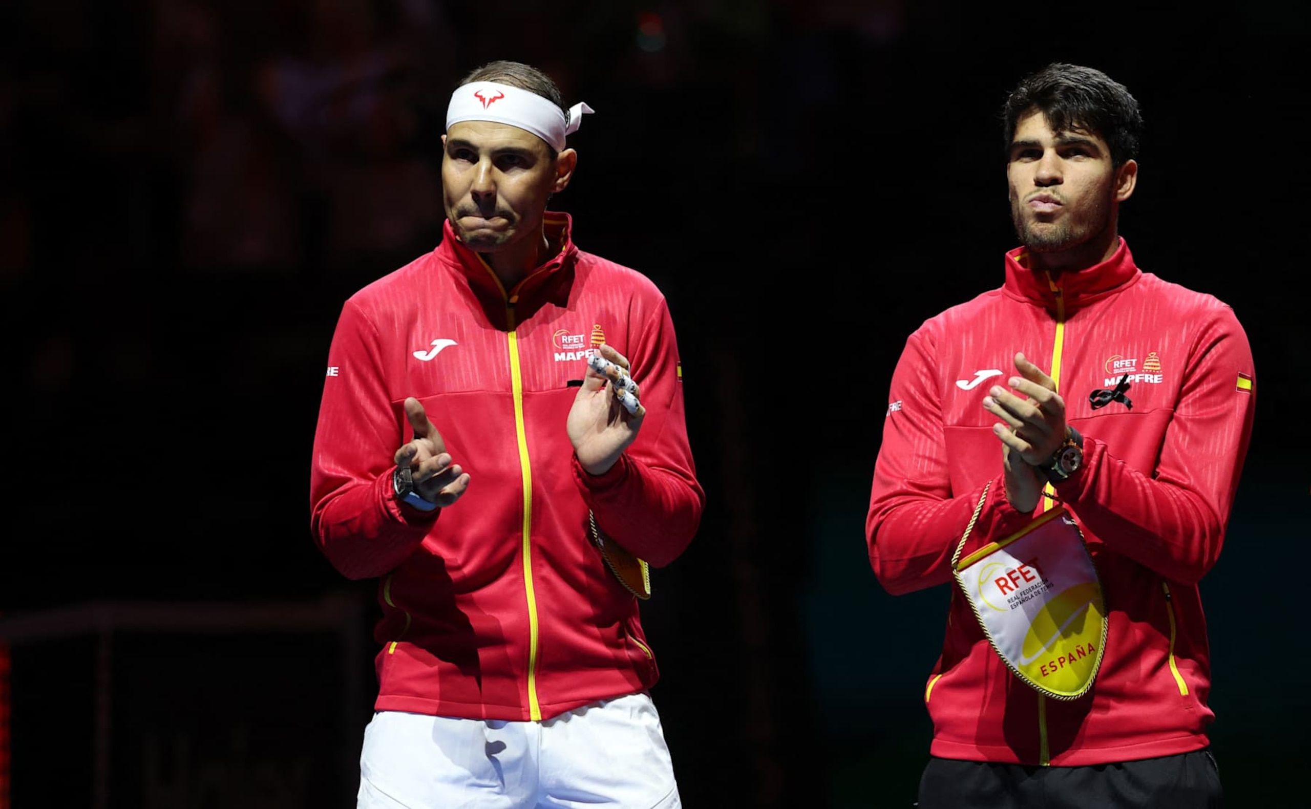 Spain's Rafael Nadal (L) applauds next to Spain's Carlos Alcaraz prior the quarter-final singles match between Netherlands and Spain during the Davis Cup Finals at the Palacio de Deportes Jose Maria Martin Carpena arena in Malaga, southern Spain, on November 19, 2024. The Davis Cup will be the final professional tournament of Nadal's glittering career of almost 23 years. (Photo by Thomas COEX / AFP) (Photo by THOMAS COEX/AFP via Getty Images) Spain's Rafael Nadal (L) applauds next to Spain's Carlos Alcaraz prior the quarter-final singles match between Netherlands and Spain during the Davis Cup Finals at the Palacio de Deportes Jose Maria Martin Carpena arena in Malaga, southern Spain, on November 19, 2024. The Davis Cup will be the final professional tournament of Nadal's glittering career of almost 23 years. (Photo by Thomas COEX / AFP) (Photo by THOMAS COEX/AFP via Getty Images)