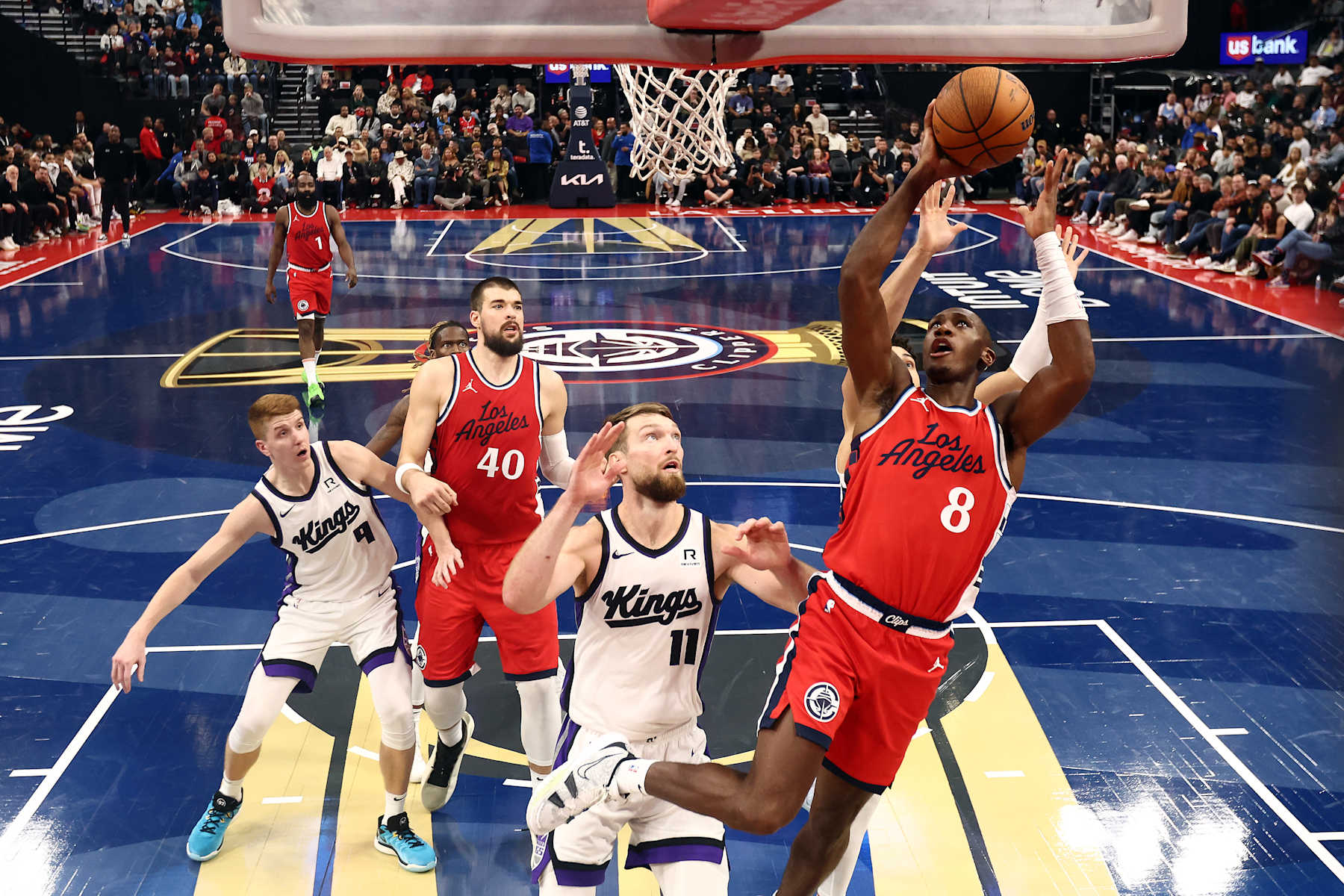 INGLEWOOD, CALIFORNIA - NOVEMBER 22: Kris Dunn #8 of the Los Angeles Clippers attempts a layup against Domantas Sabonis #11 of the Sacramento Kings during the second quarter in the Emirates NBA Cup at Intuit Dome on November 22, 2024 in Inglewood, California. NOTE TO USER: User expressly acknowledges and agrees that, by downloading and or using this photograph, User is consenting to the terms and conditions of the Getty Images License Agreement. (Photo by Katelyn Mulcahy/Getty Images)