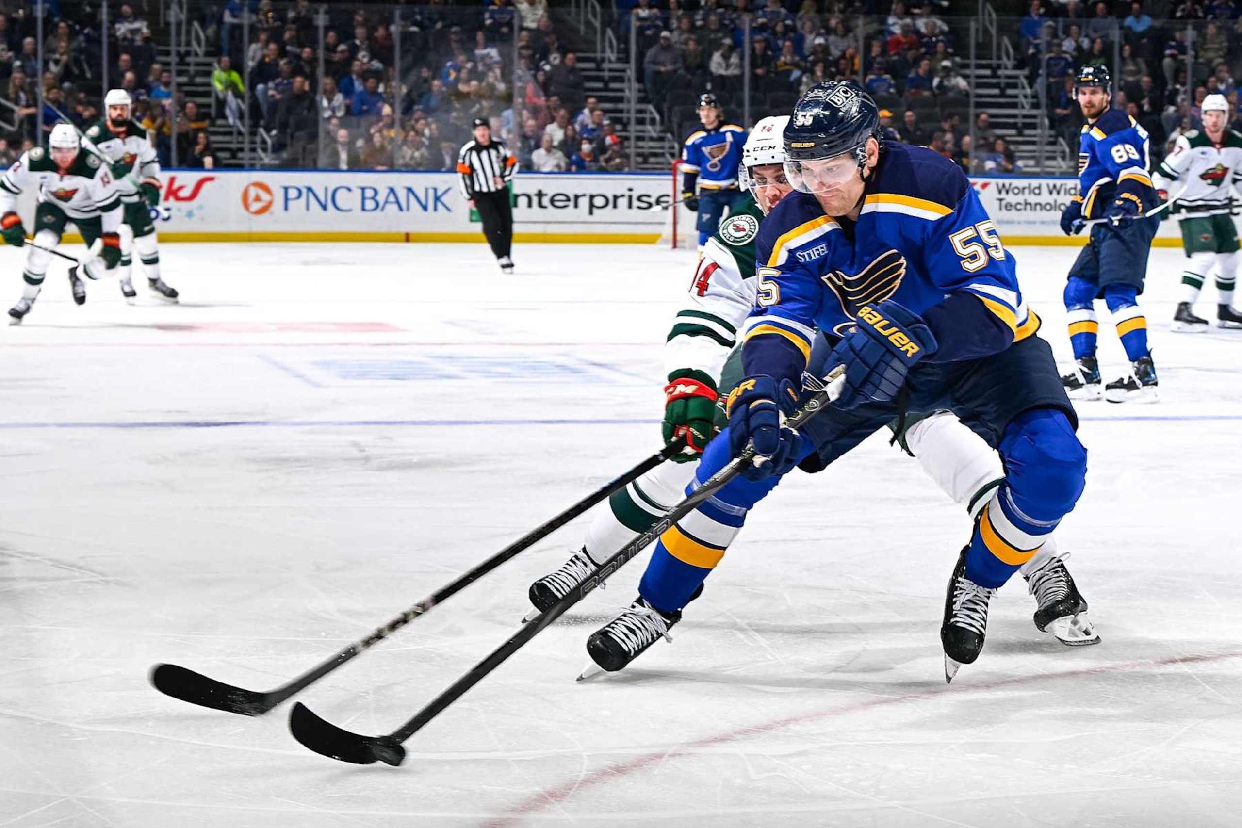 ST. LOUIS, MO - NOVEMBER 19: Colton Parayko #55 of the St. Louis Blues controls the puck as Joel Eriksson Ek #14 of the Minnesota Wild pressures on November 19, 2024 at the Enterprise Center in St. Louis, Missouri. (Photo by Scott Rovak/NHLI via Getty Images)