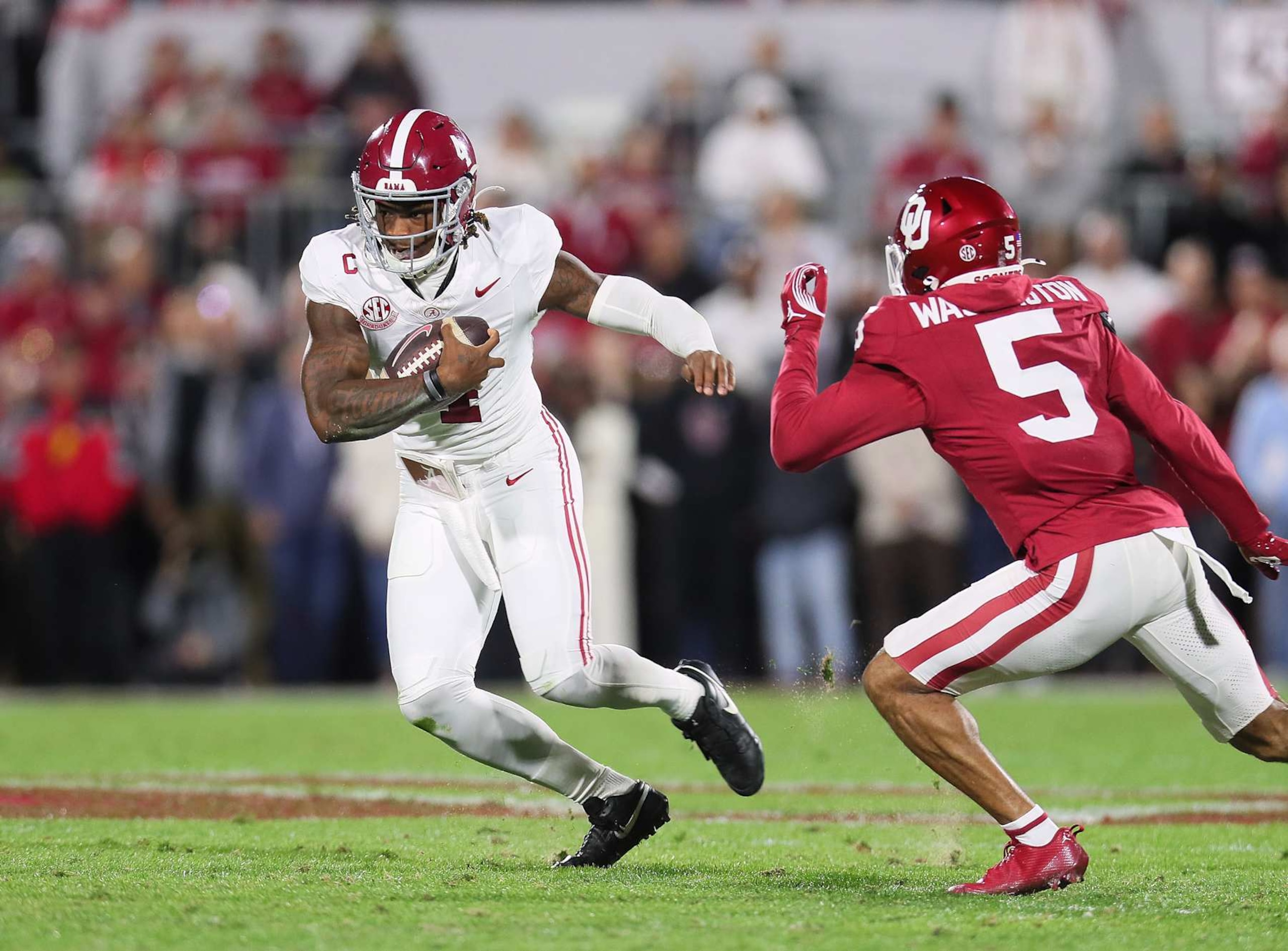 NORMAN, OK - NOVEMBER 23:Alabama Crimson Tide QB Jalen Milroe (04) running away from Oklahoma Sooners DB Woodi Washington (05) during a game between the Oklahoma Sooners and the Alabama Crimson Tide at Gaylord Memorial Stadium in Norman, Oklahoma on November 23, 2024. (Photo by David Stacy/Icon Sportswire via Getty Images) NORMAN, OK - NOVEMBER 23:Alabama Crimson Tide QB Jalen Milroe (04) running away from Oklahoma Sooners DB Woodi Washington (05) during a game between the Oklahoma Sooners and the Alabama Crimson Tide at Gaylord Memorial Stadium in Norman, Oklahoma on November 23, 2024. (Photo by David Stacy/Icon Sportswire via Getty Images)