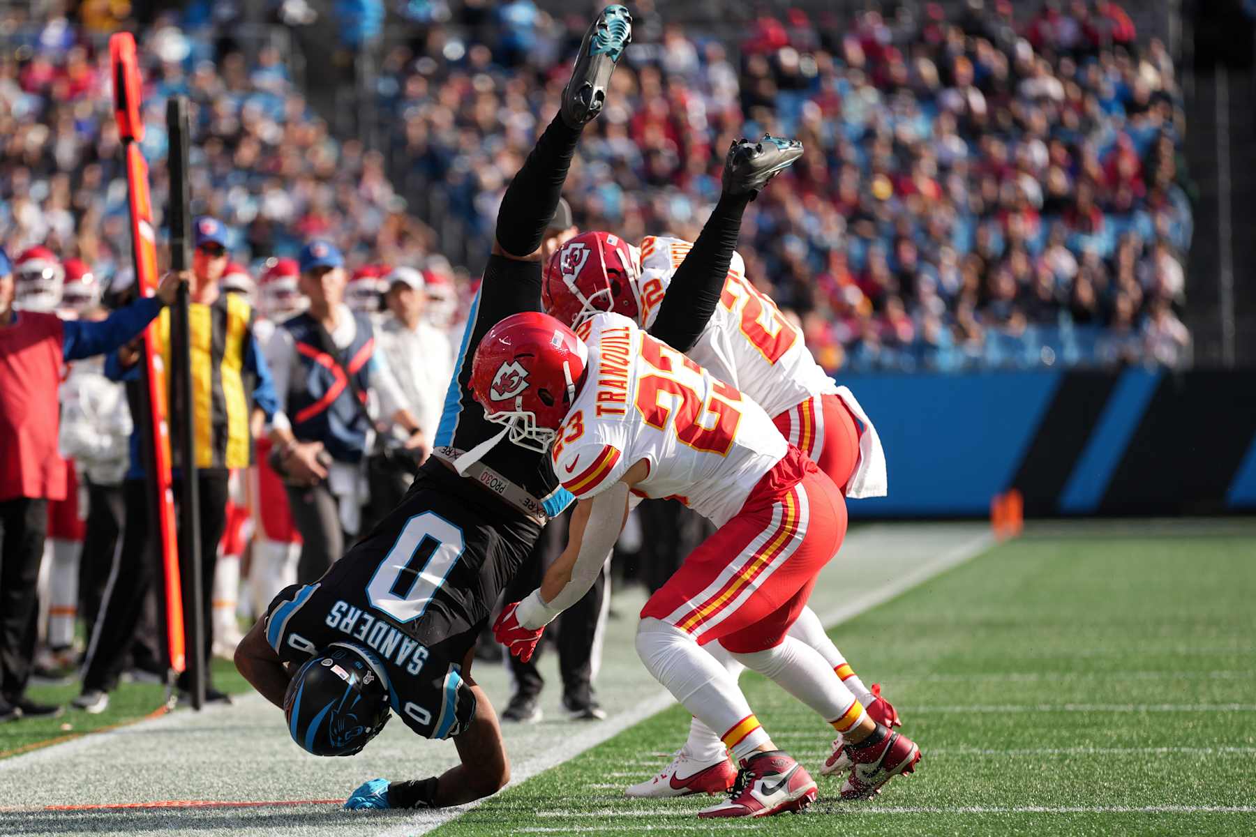 CHARLOTTE, NORTH CAROLINA - NOVEMBER 24: Drue Tranquill #23 of the Kansas City Chiefs flips Ja'Tavion Sanders #0 of the Carolina Panthers during the second quarter at Bank of America Stadium on November 24, 2024 in Charlotte, North Carolina. (Photo by Grant Halverson/Getty Images)