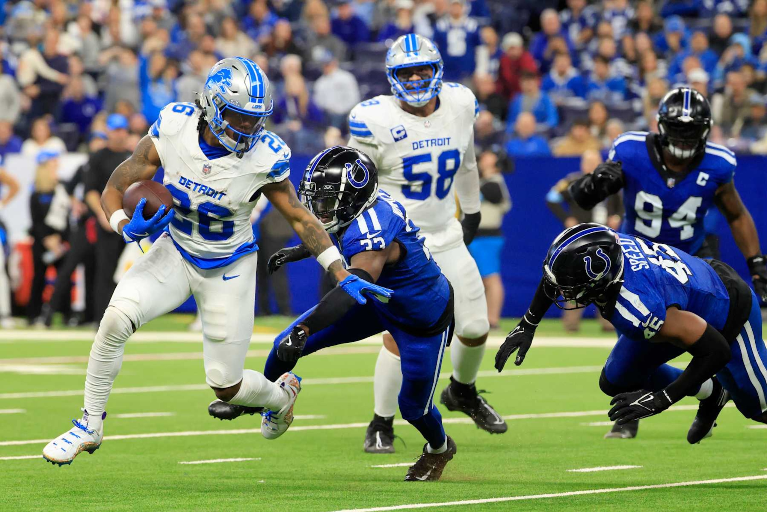 INDIANAPOLIS, INDIANA - NOVEMBER 24: Jahmyr Gibbs #26 of the Detroit Lions runs for a touchdown against Samuel Womack III #33 and E.J. Speed #45 of the Indianapolis Colts during the third quarter at Lucas Oil Stadium on November 24, 2024 in Indianapolis, Indiana. (Photo by Justin Casterline/Getty Images)