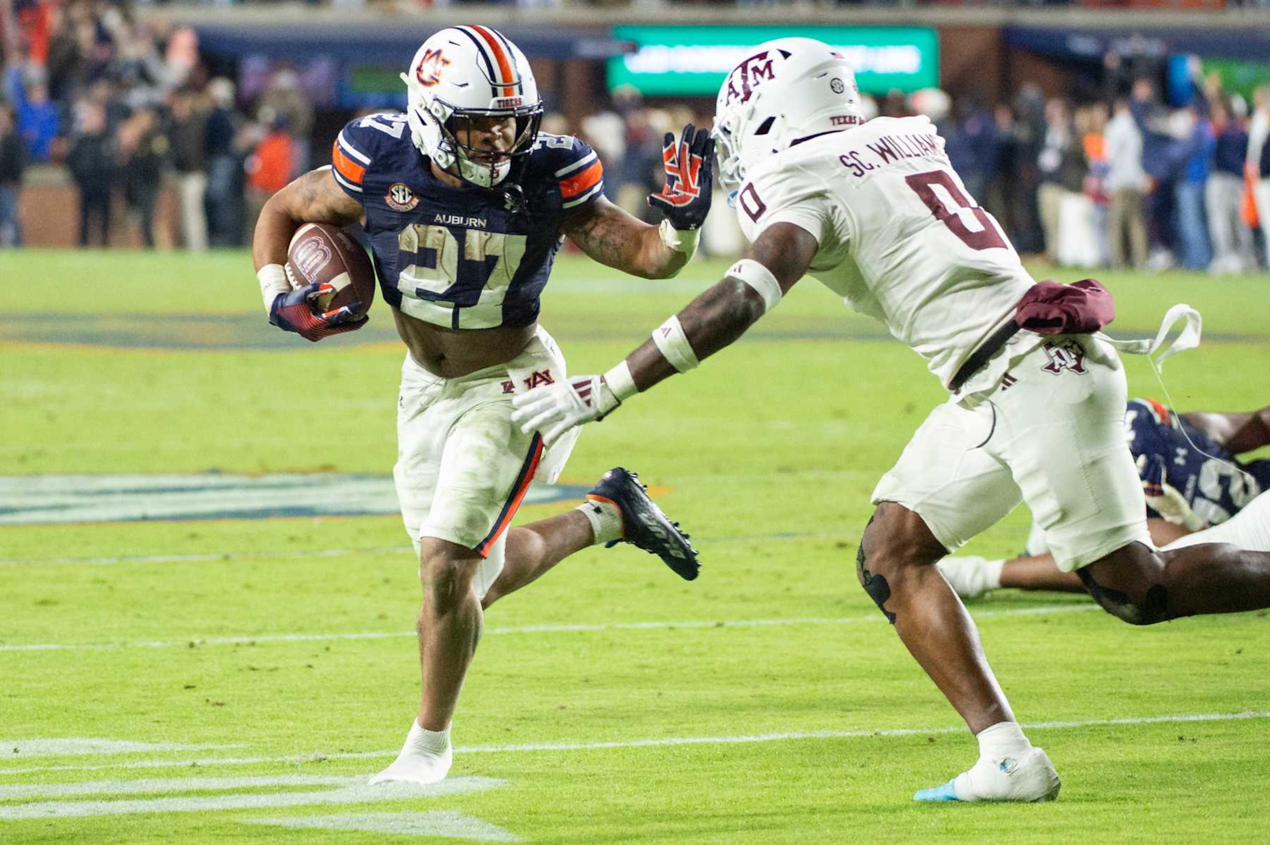 AUBURN, ALABAMA - NOVEMBER 23: Running back Jarquez Hunter #27 of the Auburn Tigers looks to run the ball by linebacker Scooby Williams #0 of the Texas A&M Aggies during overtime at Jordan-Hare Stadium on November 23, 2024 in Auburn, Alabama. (Photo by Michael Chang/Getty Images)