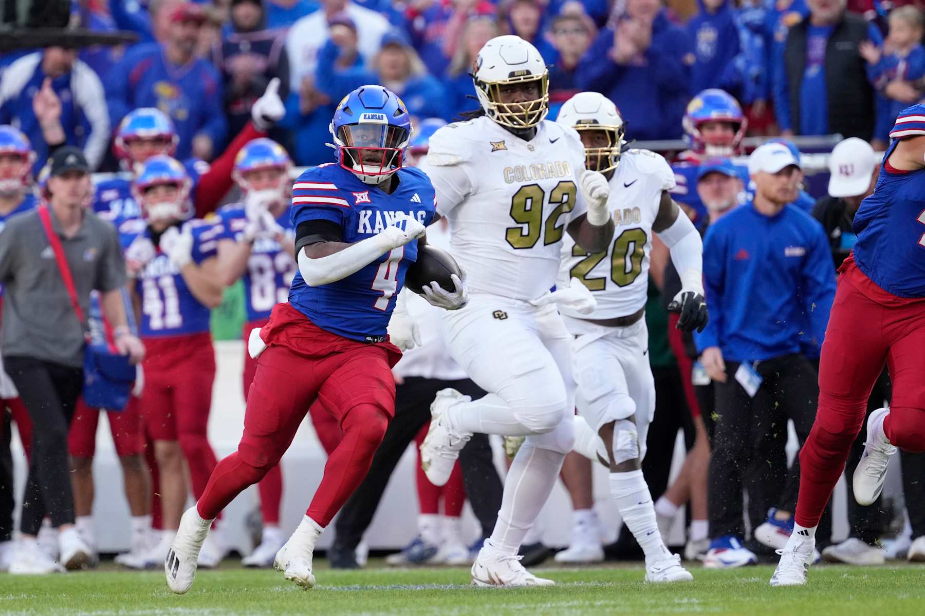 KANSAS CITY, MISSOURI - NOVEMBER 23: Running back Devin Neal #4 of the Kansas Jayhawks runs for a touchdown against defensive tackle Anquin Barnes Jr. #92 of the Colorado Buffaloes in the first half at Arrowhead Stadium on November 23, 2024 in Kansas City, Missouri.  (Photo by Ed Zurga/Getty Images)
