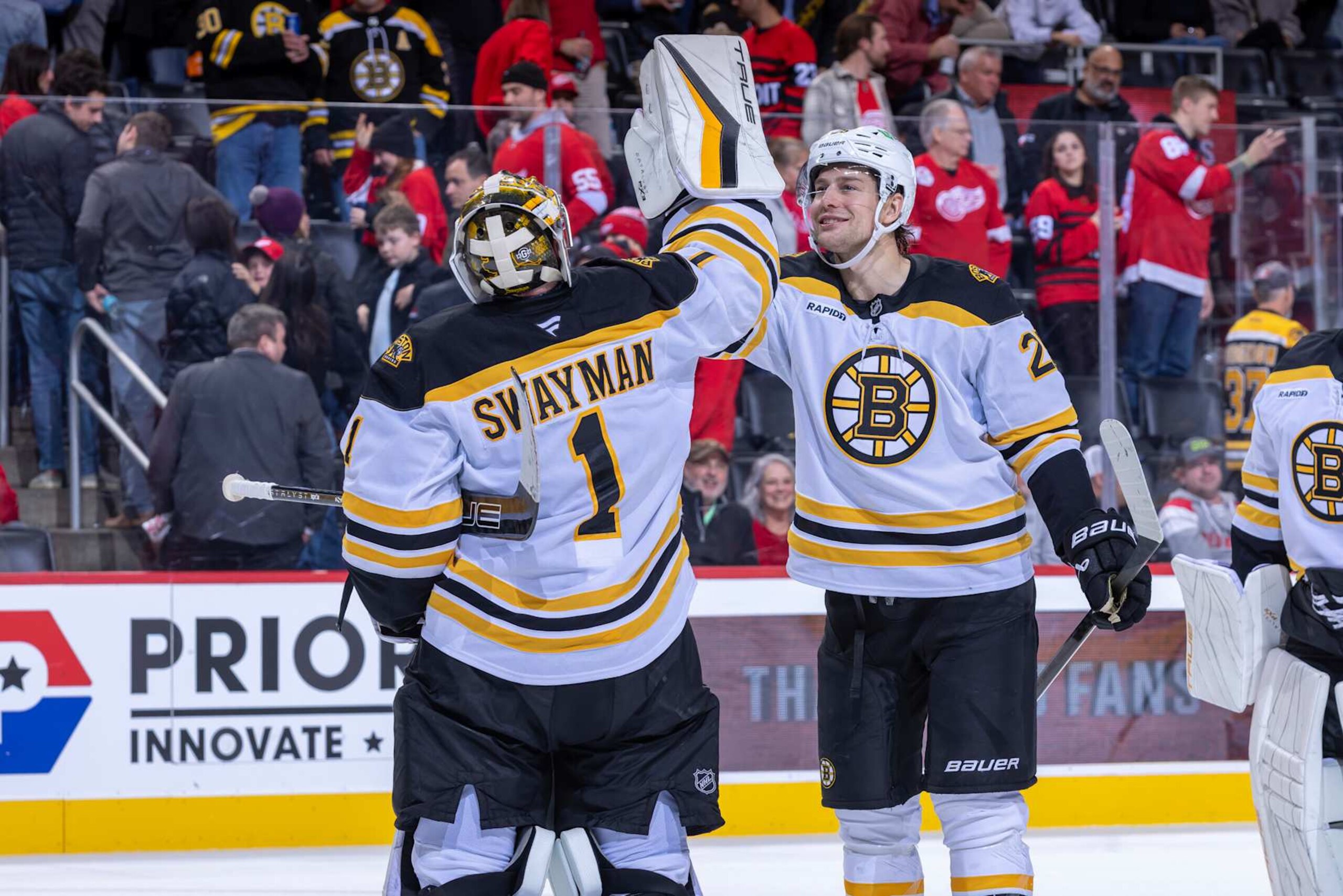 DETROIT, MICHIGAN-NOVEMBER 23: Jeremy Swayman #1 of the Boston Bruins celebrates the win with Brandon Carlo #25 after the game against the Detroit Red Wings at Little Caesars Arena on November 23, 2024 in Detroit, Michigan. Boston defeated  Detroit 2-1. (Photo by Dave Reginek/NHLI via Getty Images)