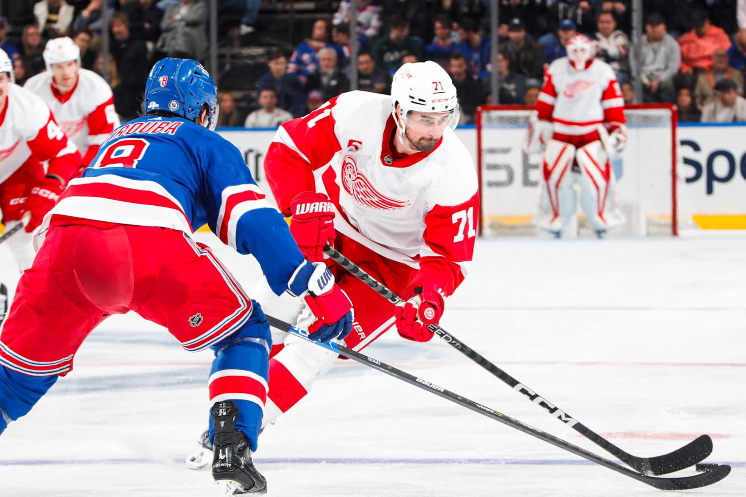 NEW YORK, NEW YORK - NOVEMBER 07:  Dylan Larkin #71 of the Detroit Red Wings skates with the puck against Jacob Trouba #8 of the New York Rangers at Madison Square Garden on November 7, 2023 in New York City. (Photo by Jared Silber/NHLI via Getty Images)