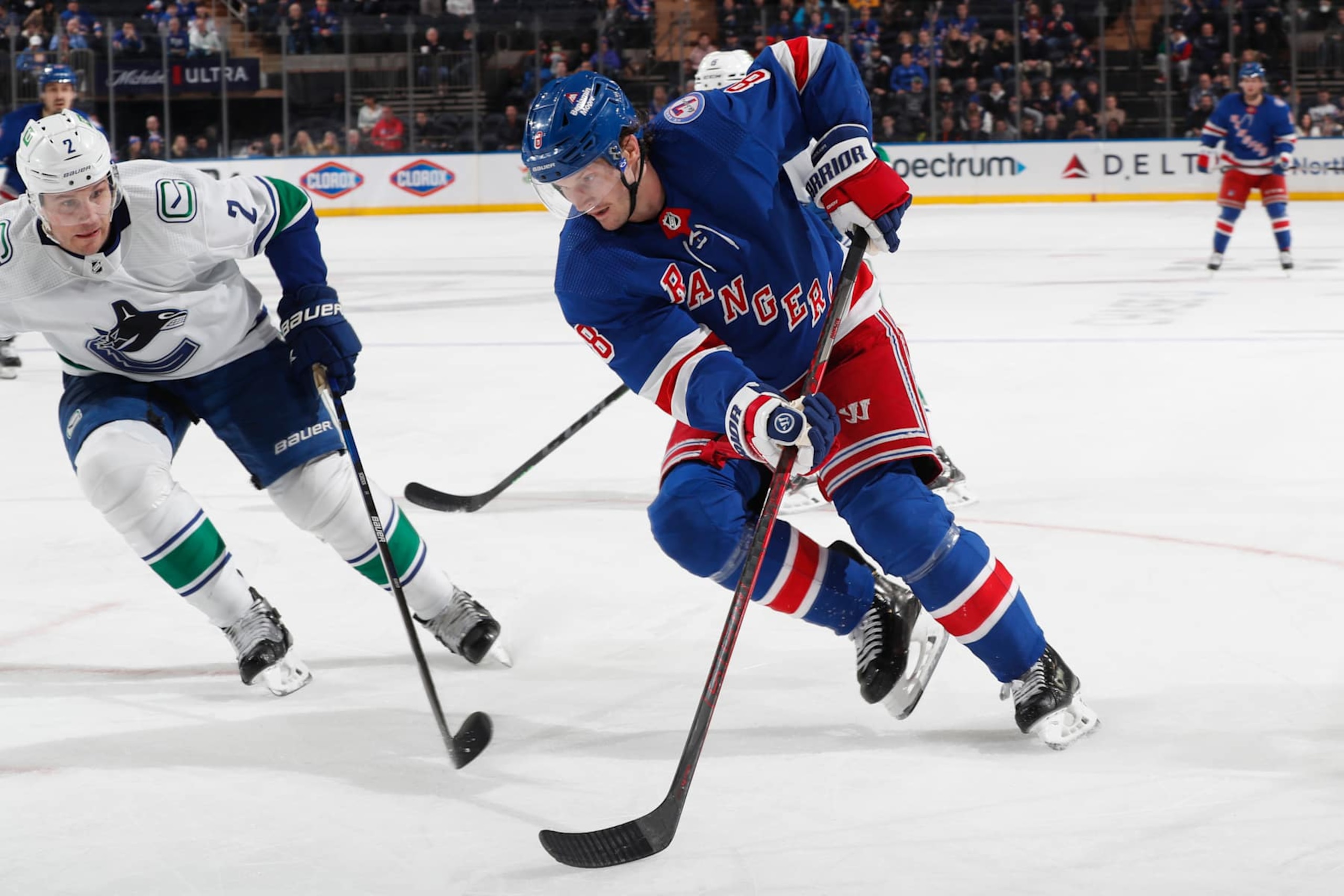 NEW YORK, NY - FEBRUARY 27:  Jacob Trouba #8 of the New York Rangers skates with the puck against Luke Schenn #2 of the Vancouver Canucks at Madison Square Garden on February 27, 2022 in New York City. (Photo by Jared Silber/NHLI via Getty Images)