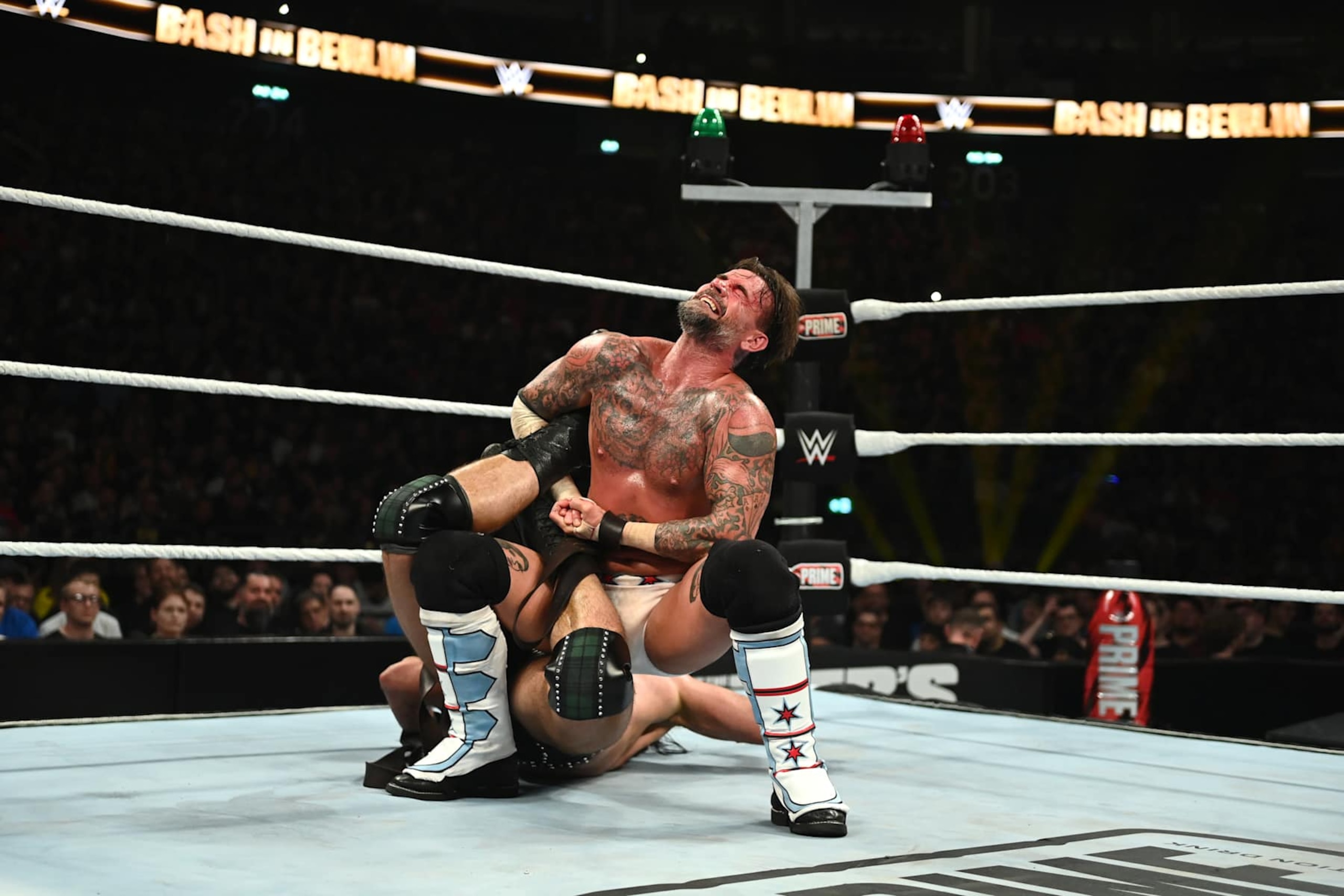 BERLIN, GERMANY - AUGUST 31: CM Punk locks in a sharpshooter against Drew McIntyre during their strap match at the WWE Bash in Berlin Premium Live Event at Uber Arena on August 31, 2024 in Berlin, Germany.  (Photo by WWE/Getty Images)