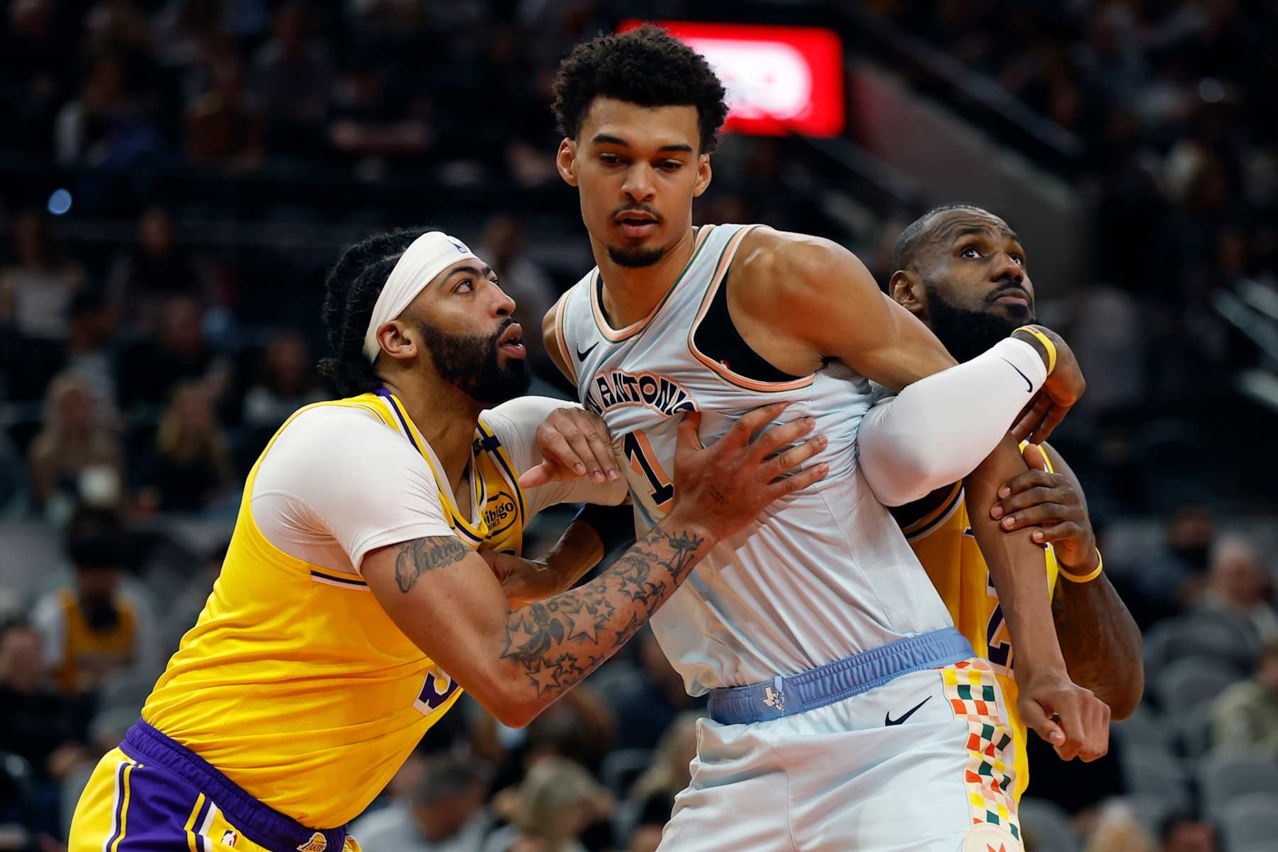 SAN ANTONIO, TEXAS - NOVEMBER 27: Victor Wembanyama #1 of the San Antonio Spurs blocks out Anthony Davis #3 and LeBron James #23 of the Los Angeles Lakers during the first quarter at Frost Bank Center on November 27, 2024 in San Antonio, Texas. NOTE TO USER: User expressly acknowledges and agrees that, by downloading and or using this photograph, User is consenting to the terms and conditions of the Getty Images License Agreement (Photo by Ronald Cortes/Getty Images)
