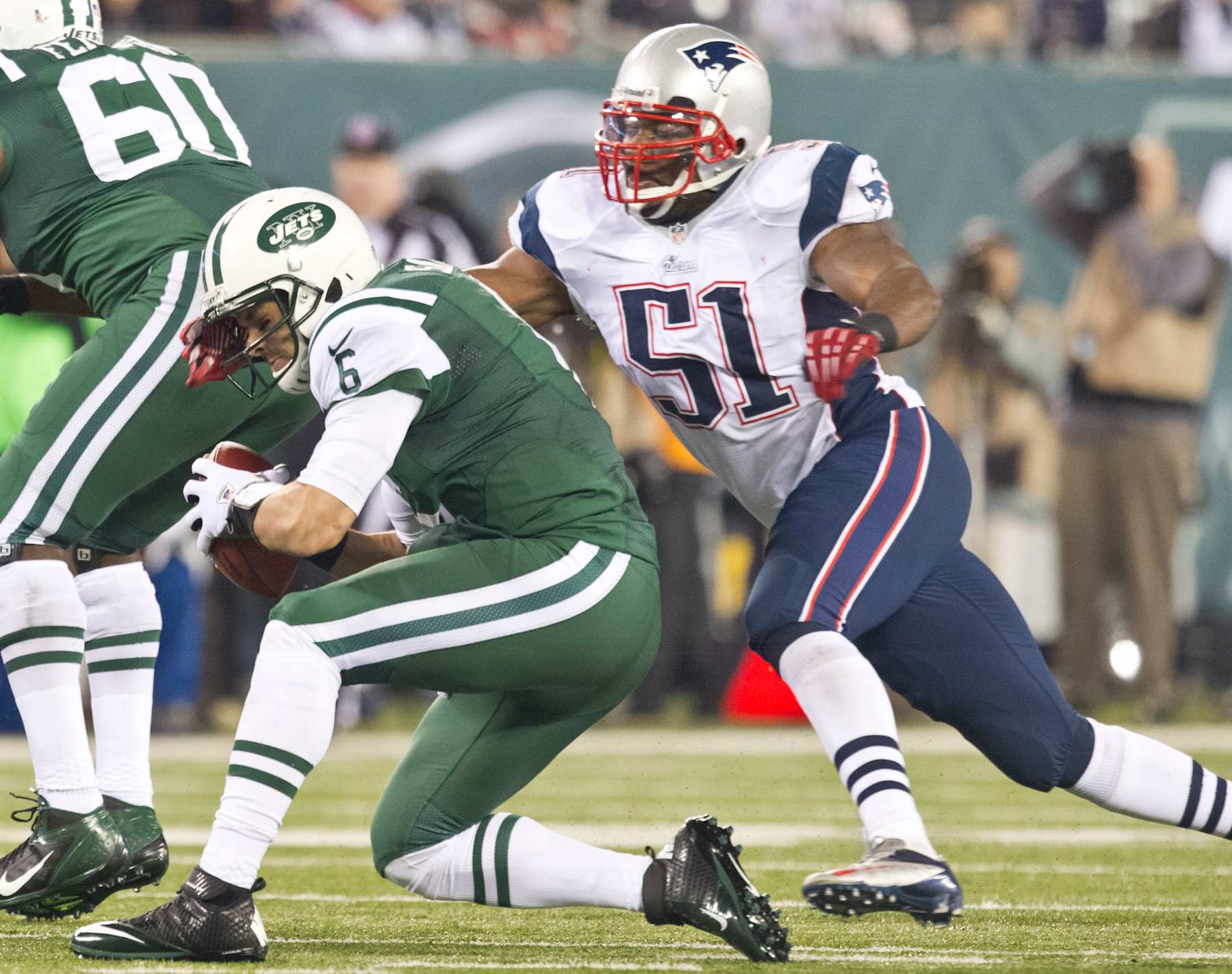 EAST RUTHERFORD, NJ - NOVEMBER 22: New England Patriots player Jerod Mayo sacks New York Jets quarterback Mark Sanchez during second quarter action at Metlife Stadium on Thursday, Nov. 22, 2012. (Photo by Matthew J. Lee/The Boston Globe via Getty Images)