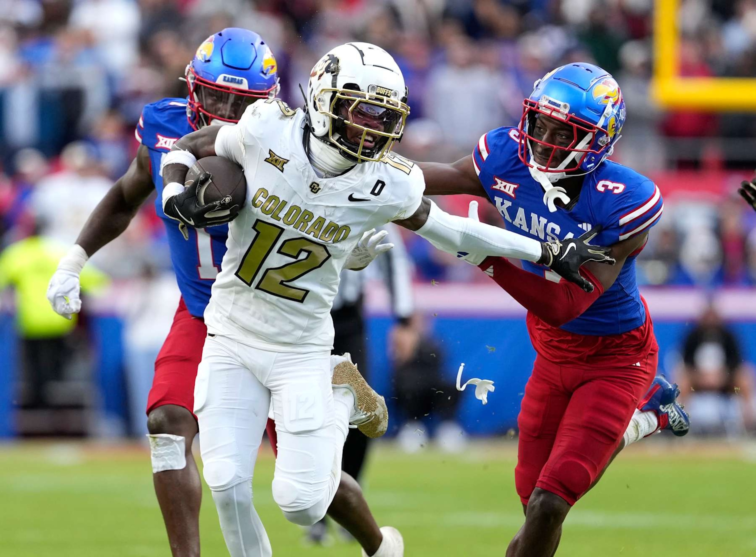 KANSAS CITY, MISSOURI - NOVEMBER 23: Wide receiver Travis Hunter #12 of the Colorado Buffaloes runs with the ball against cornerback Mello Dotson #3 of the Kansas Jayhawks in the first half at Arrowhead Stadium on November 23, 2024 in Kansas City, Missouri. (Photo by Ed Zurga/Getty Images) KANSAS CITY, MISSOURI - NOVEMBER 23: Wide receiver Travis Hunter #12 of the Colorado Buffaloes runs with the ball against cornerback Mello Dotson #3 of the Kansas Jayhawks in the first half at Arrowhead Stadium on November 23, 2024 in Kansas City, Missouri. (Photo by Ed Zurga/Getty Images)