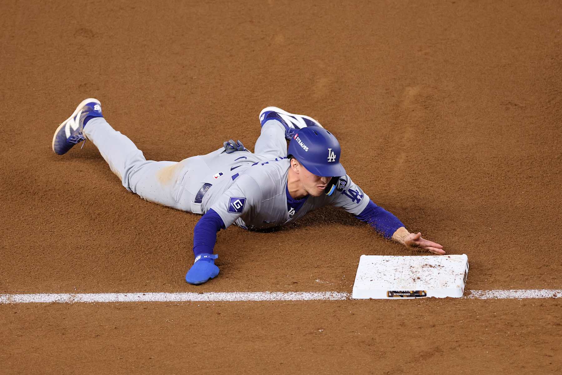 NEW YORK, NEW YORK - OCTOBER 30:  Tommy Edman #25 of the Los Angeles Dodgers slides into third during the eighth inning of Game Five of the 2024 World Series against the New York Yankees at Yankee Stadium on October 30, 2024 in the Bronx borough of New York City. (Photo by Luke Hales/Getty Images)