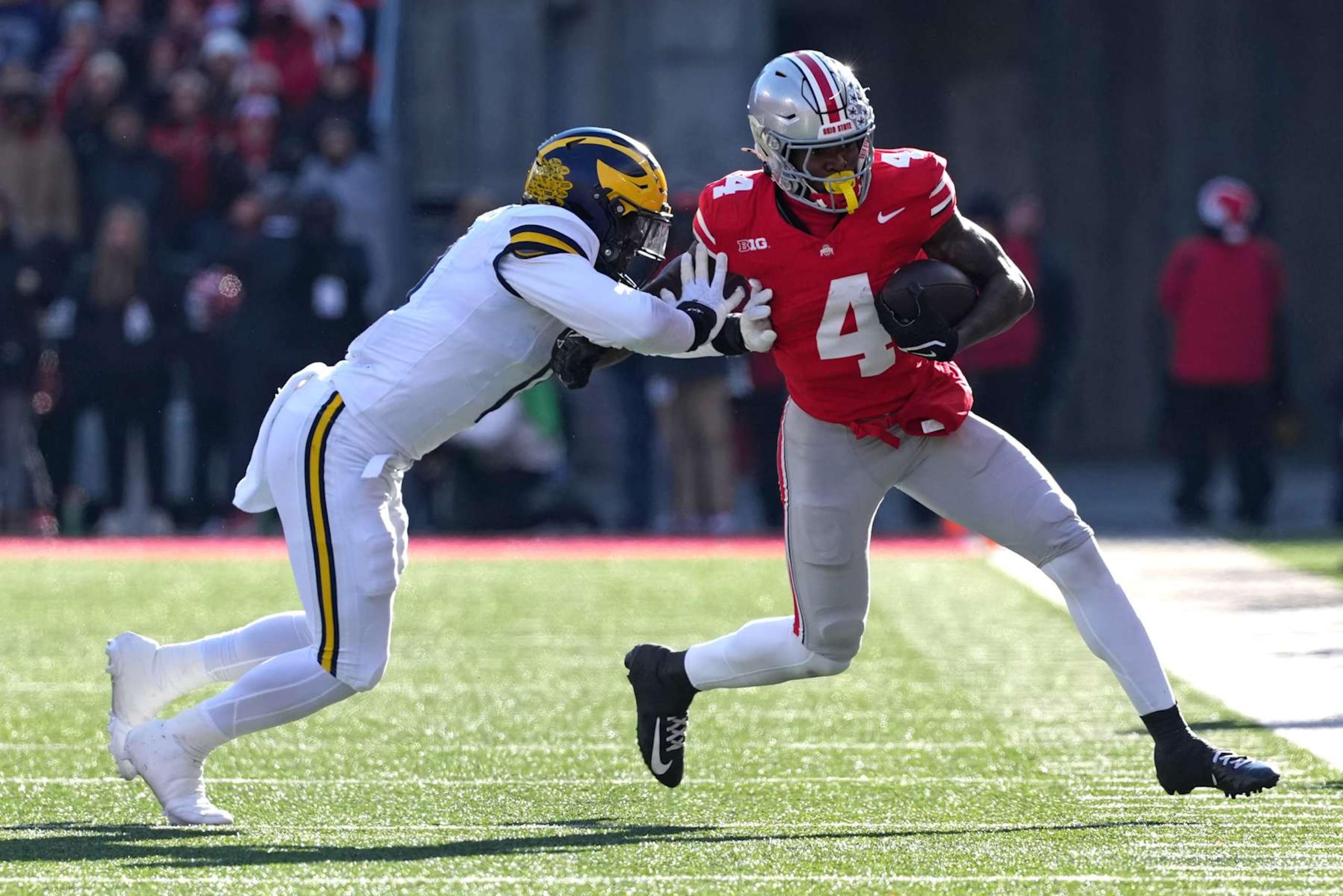 COLUMBUS, OHIO - NOVEMBER 30: Jeremiah Smith #4 of the Ohio State Buckeyes is pushed out of bounds by Josaiah Stewart #0 of the Michigan Wolverines during the third quarter at Ohio Stadium on November 30, 2024 in Columbus, Ohio. (Photo by Jason Mowry/Getty Images)