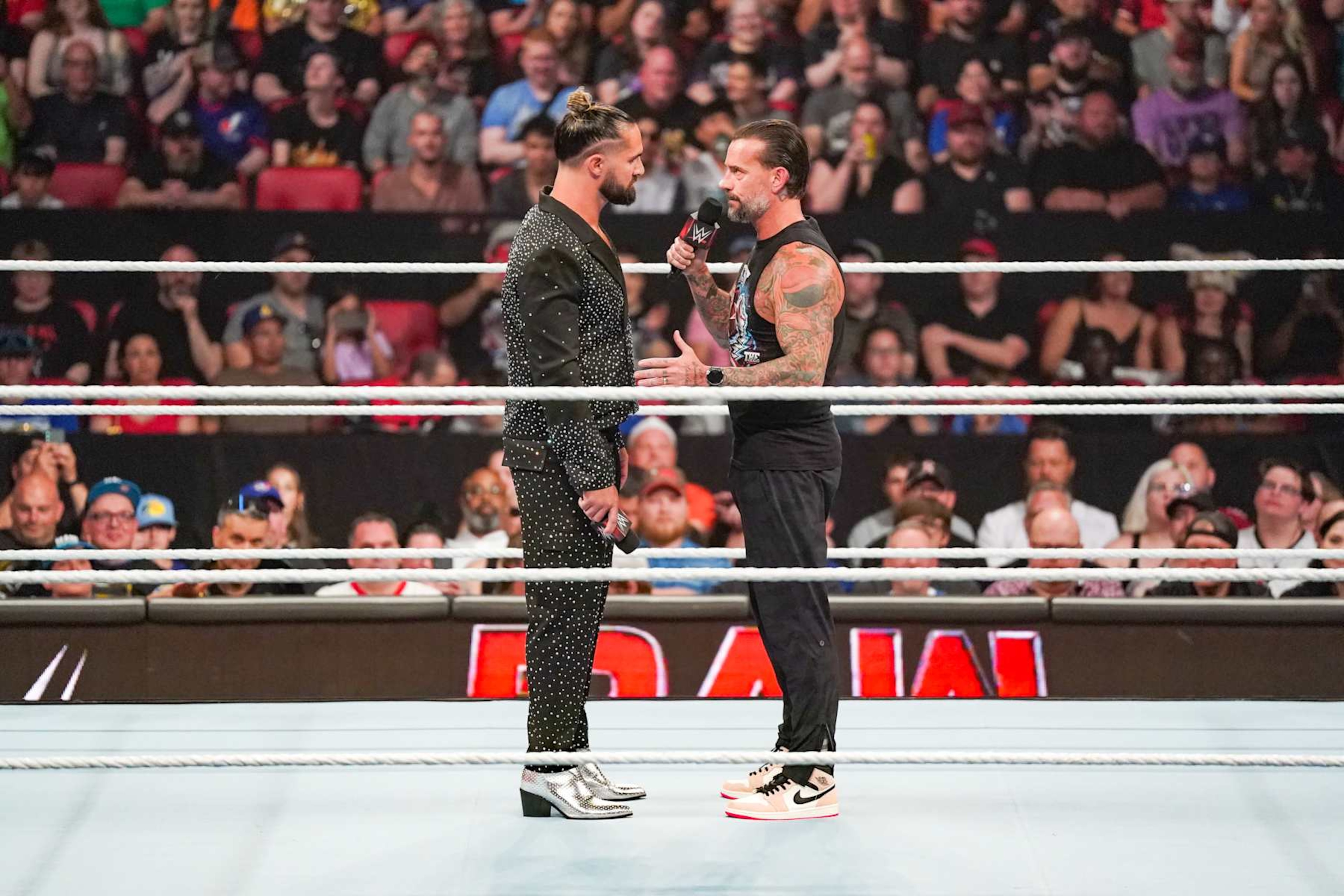 OTTAWA, CANADA - JULY 8: Seth Rollins and CM Punk have a chat in the ring during Monday Night RAW at Canadian Tire Centre on July 8, 2024 in Ottawa, Ontario.  (Photo by WWE/Getty Images)