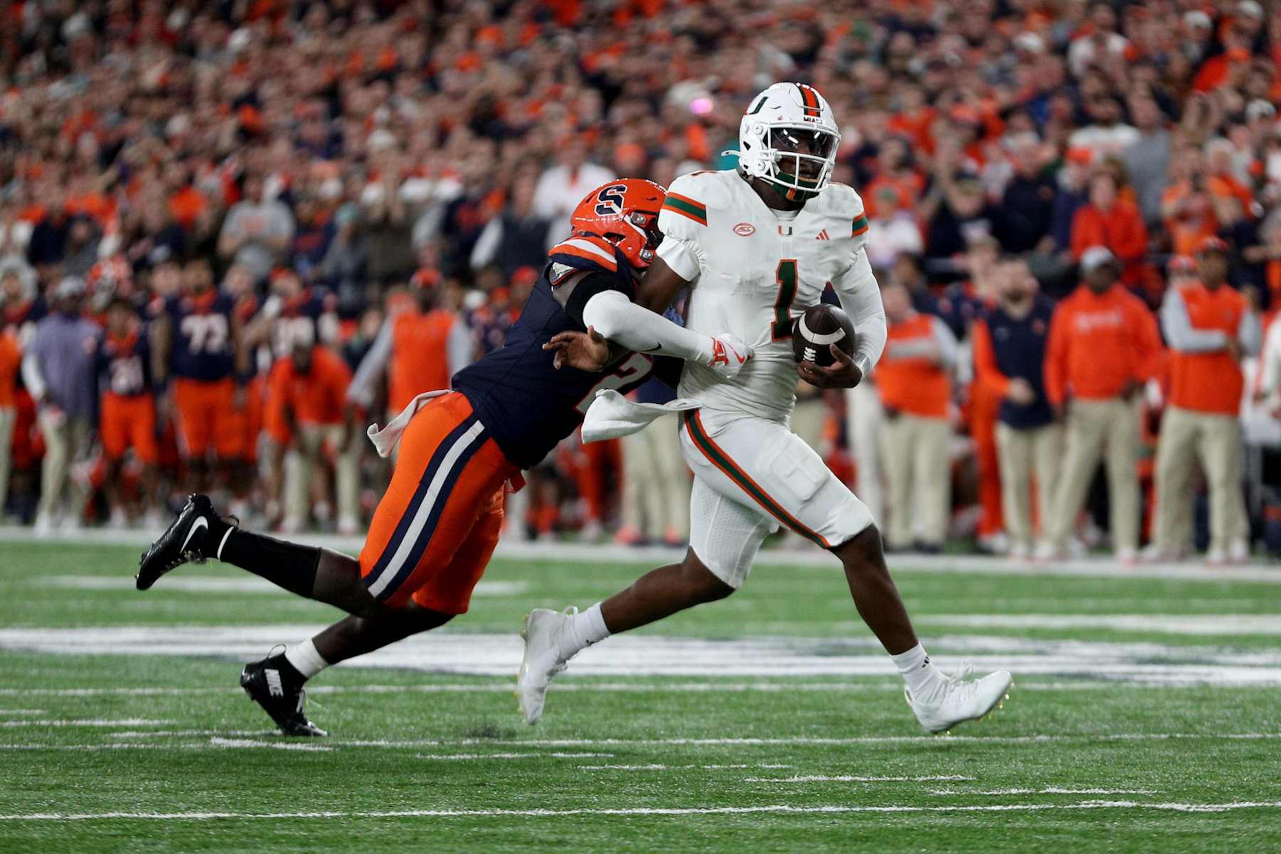 SYRACUSE, NEW YORK - NOVEMBER 30: Marlowe Wax #2 of the Syracuse Orange tackles Cam Ward #1 of the Miami Hurricanes during the fourth quarter at JMA Wireless Dome on November 30, 2024 in Syracuse, New York. (Photo by Bryan M. Bennett/Getty Images)